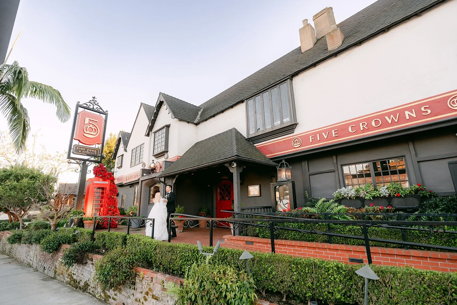 Wide view of Valerie and Jason in front of the Tudor style building at Five Crowns