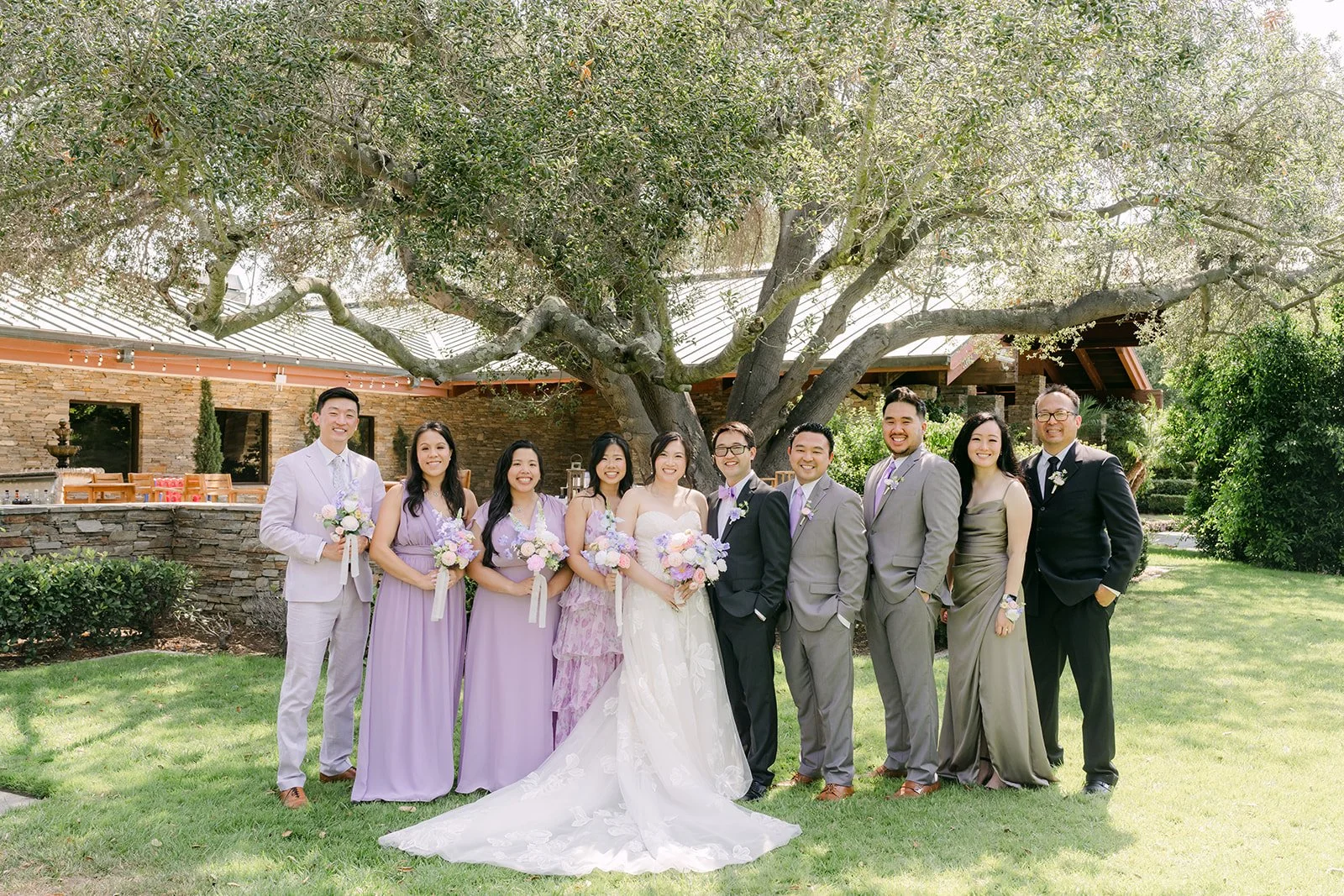 The full wedding party under the oak tree