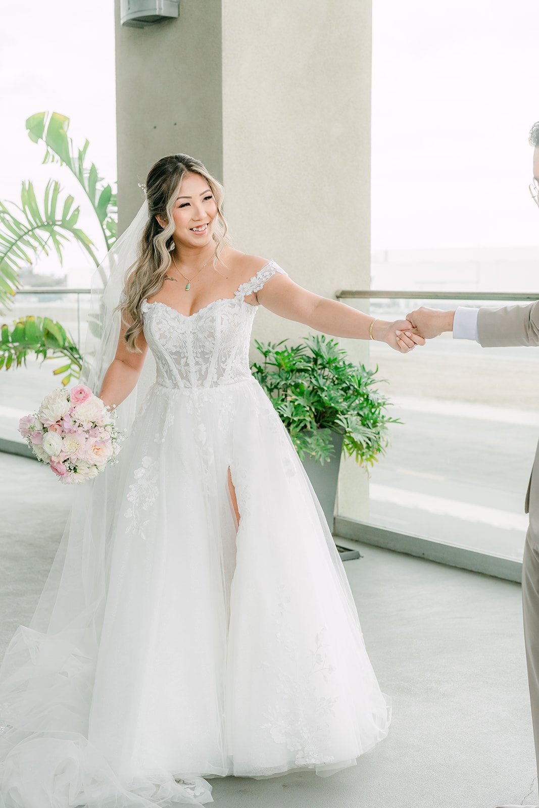 Bride twirling in her gown while holding the groom's hand
