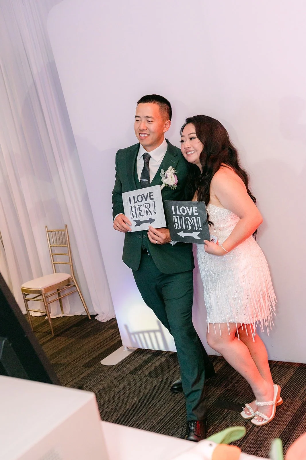 Jennifer and Kevin hold up I love her and I love him signs