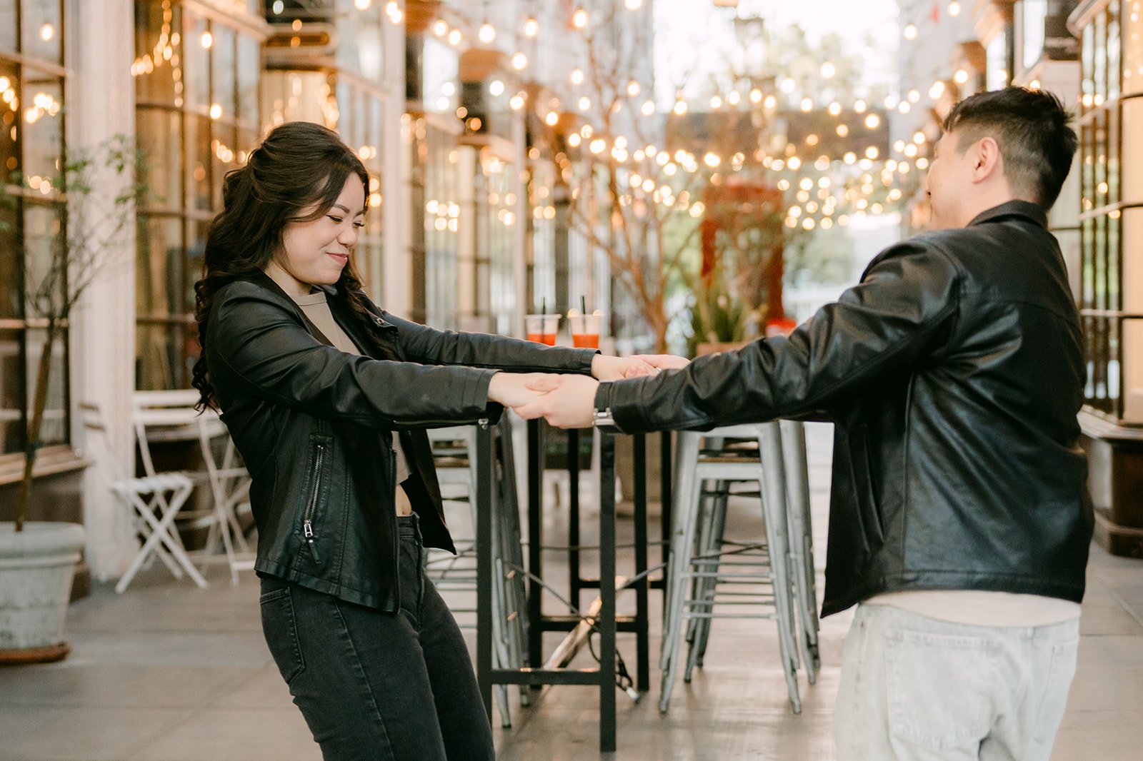 Emily and James reach for each other playfully in the arcade.