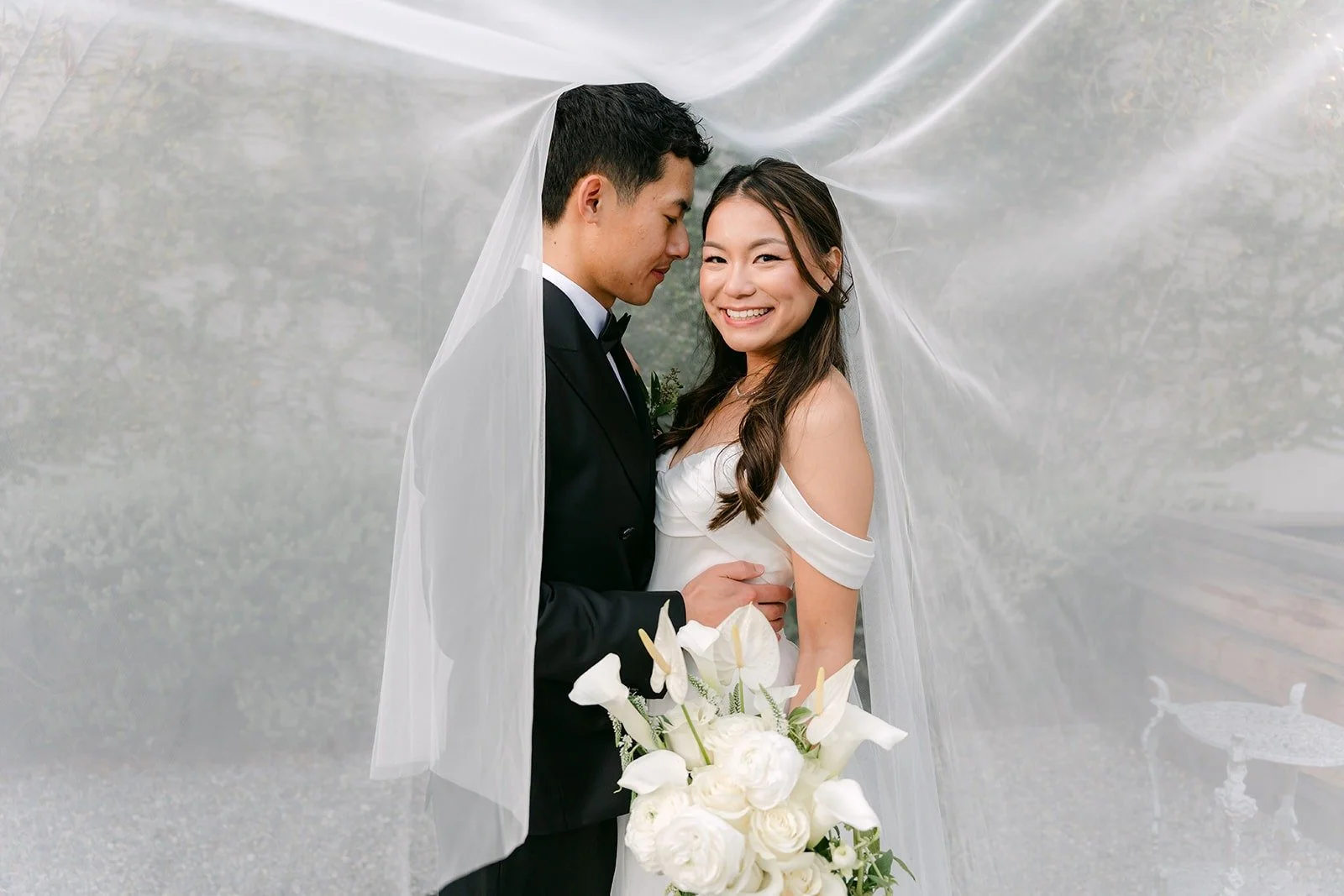 Jadee and Richard smiling under the veil