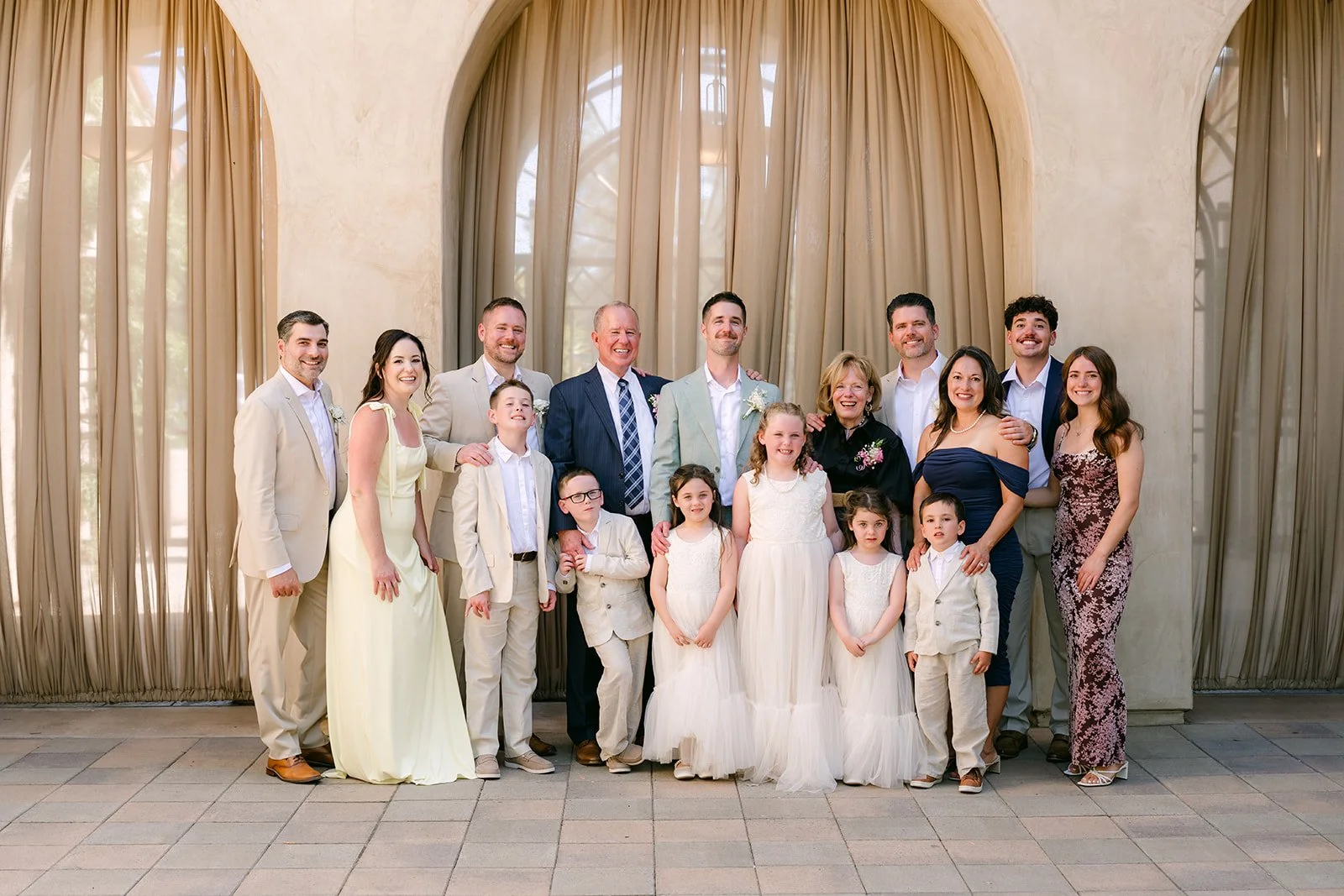 Large family group portrait beneath the curtains at Serra Plaza