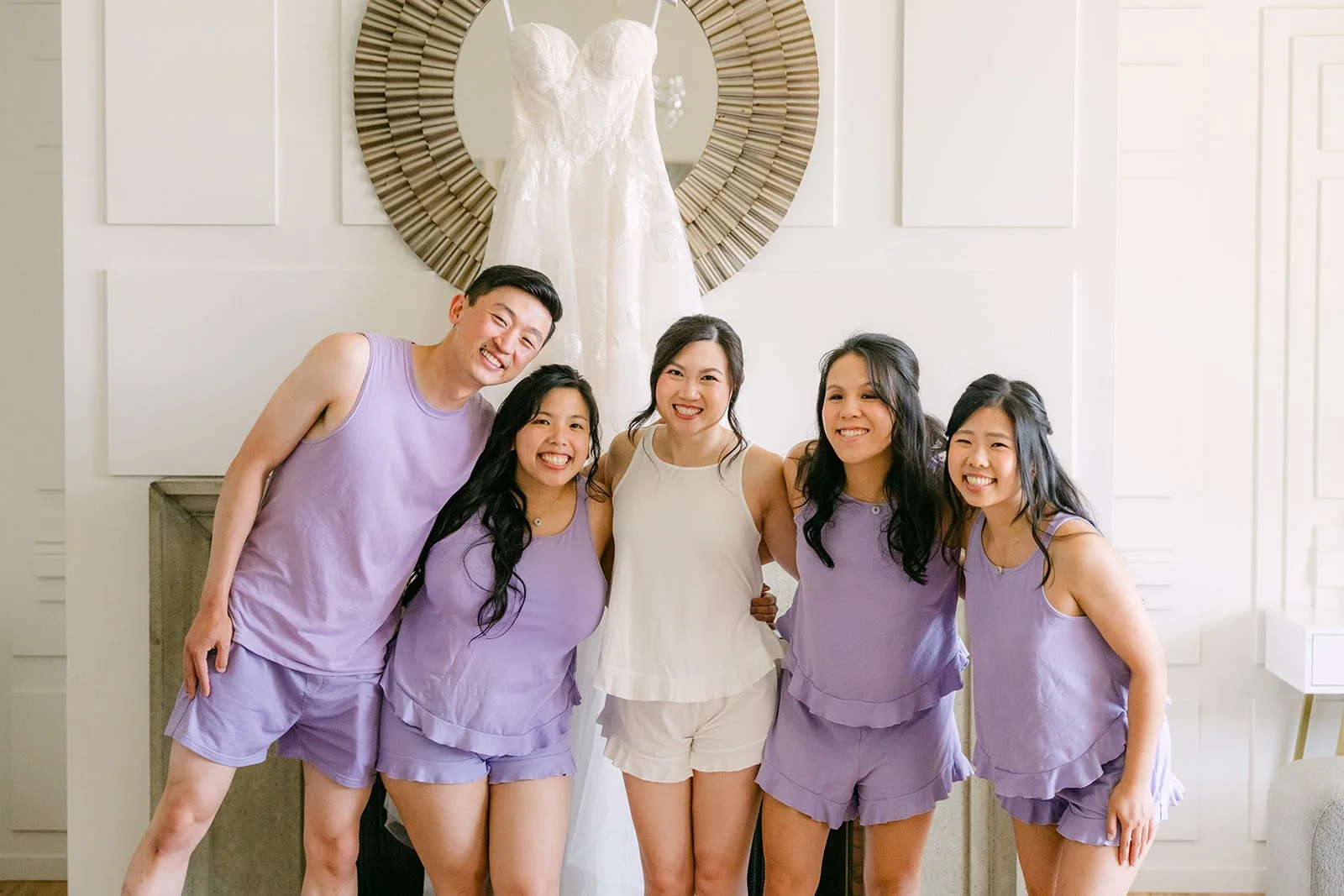 The bridal party posing beneath the gown