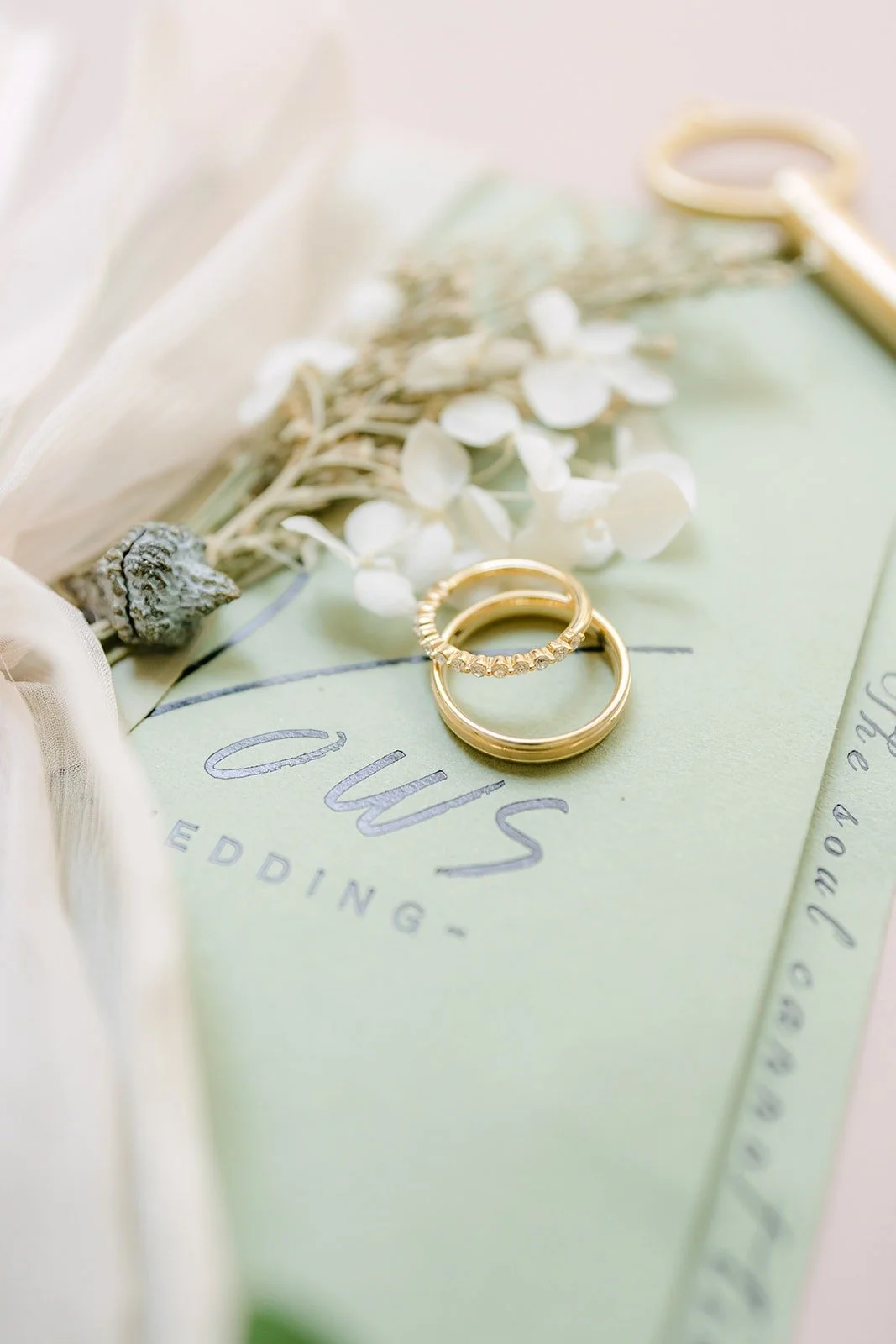 Wedding bands on a sage green vow book