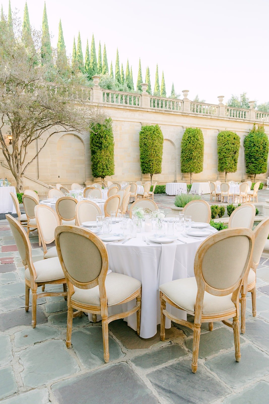 Long reception tables lined up beside the hedges