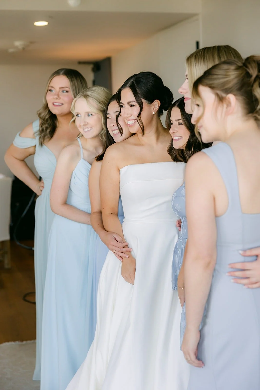 Brianna laughing with her bridesmaids in dusty blue