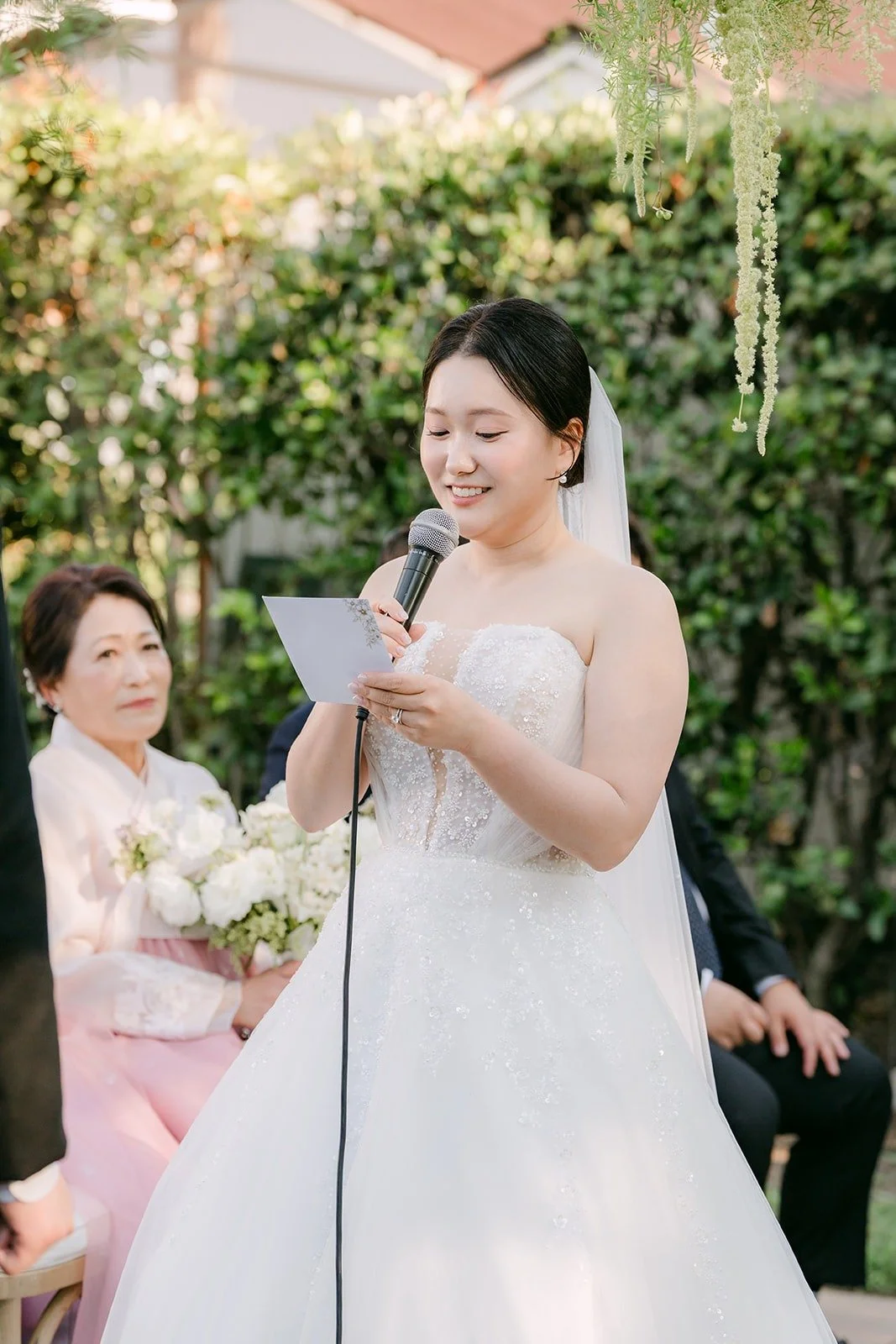 Amy reading her vows under the arbor