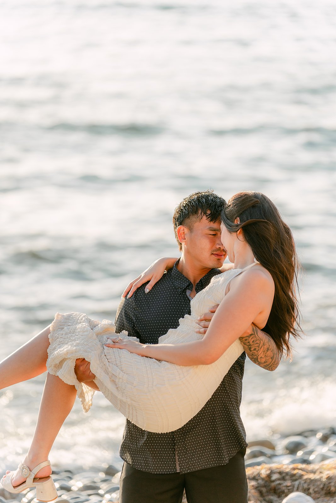 Andrew lifts Victoria into his arms at the shoreline.