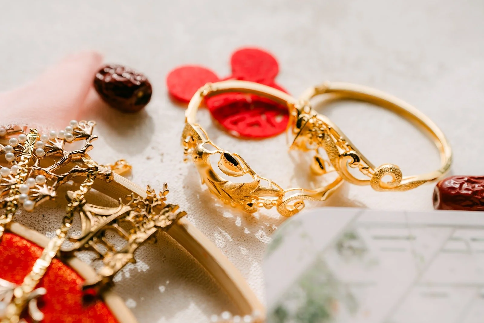 Gold bangles and wedding jewelry on red silk