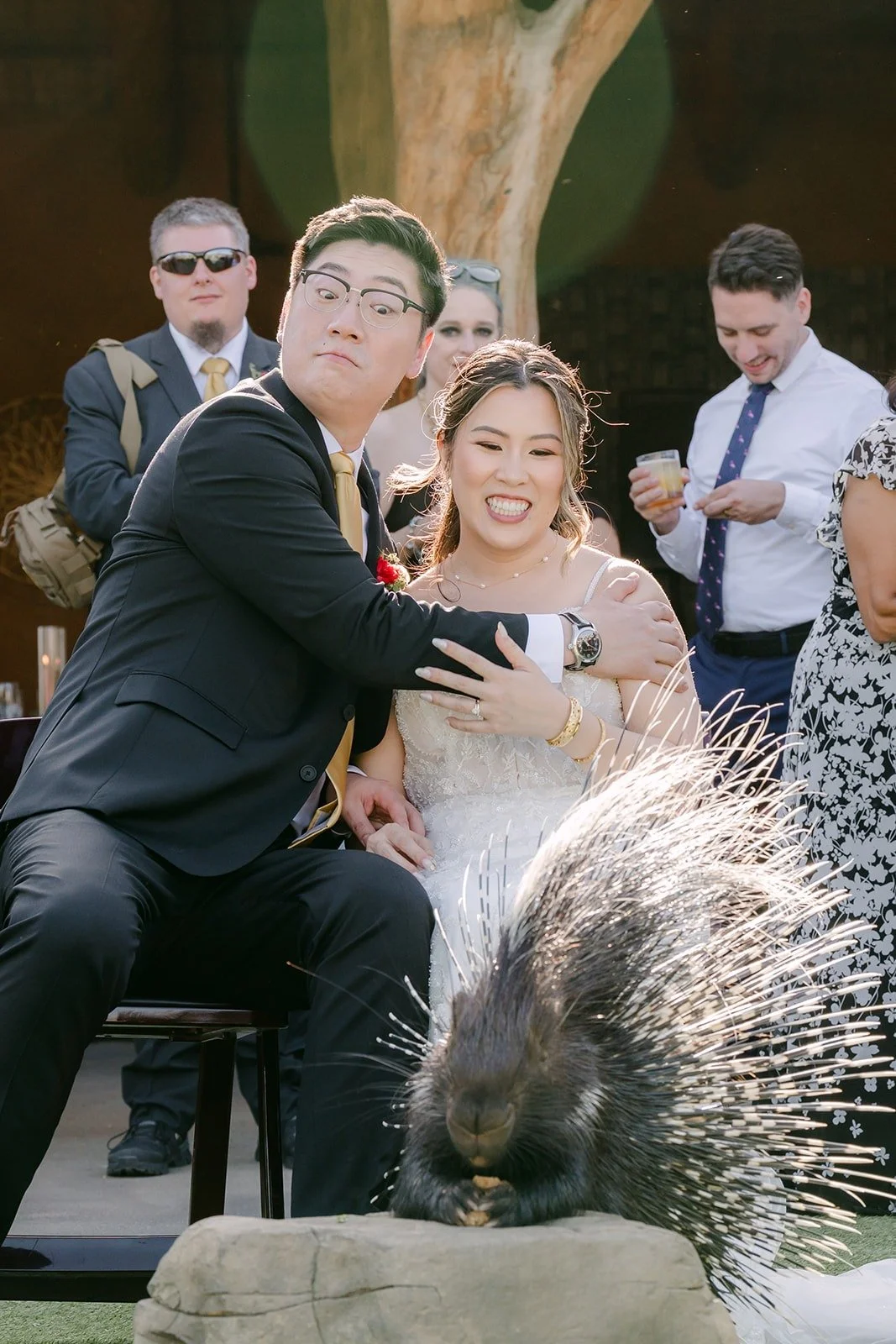Joanne and Zach smiling as a porcupine wanders past their chairs