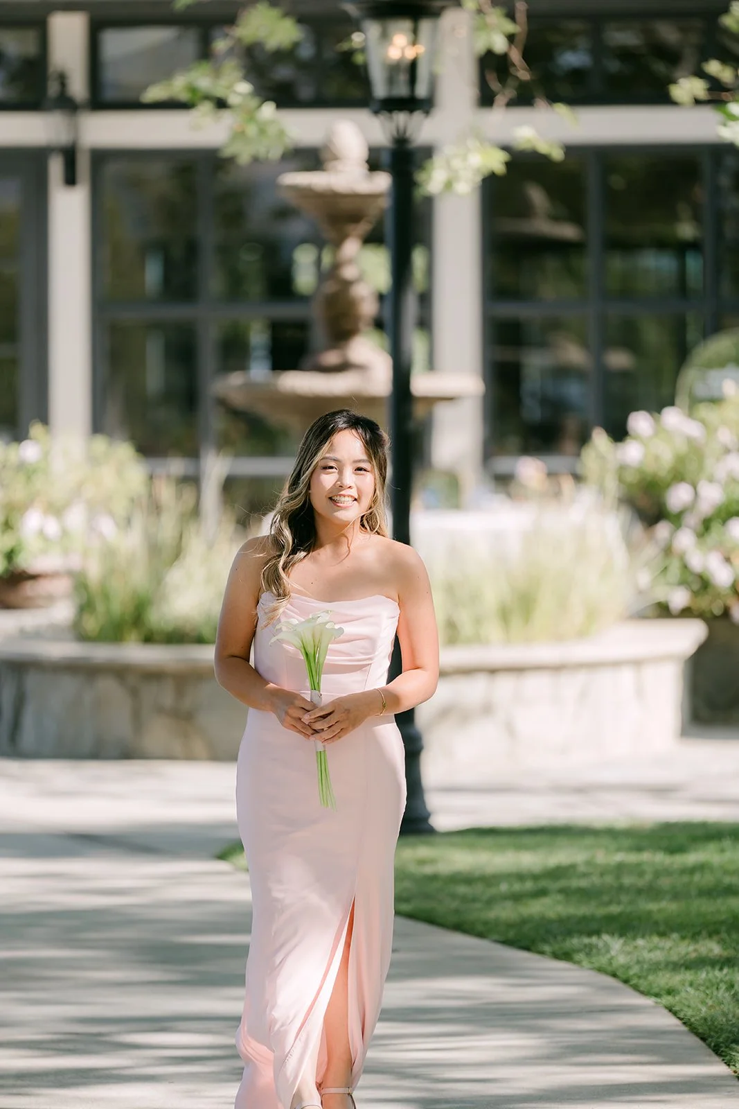 A bridesmaid in blush walking down the aisle