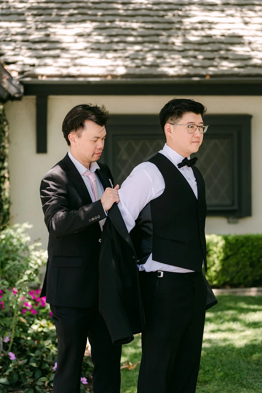 A groomsman helping Joshua with his bow tie