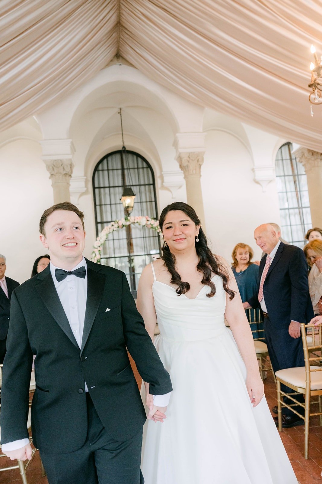Matthew and Saira smiling as they head up the aisle
