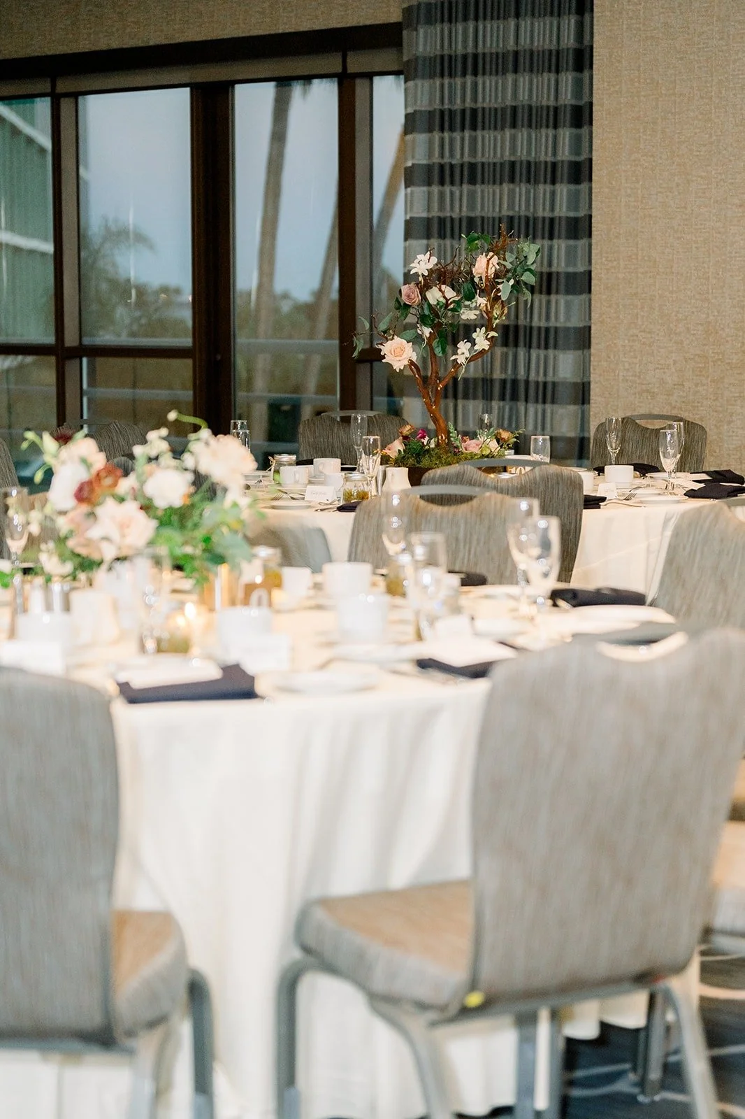 A table set with white linens and grey chairs at Hyatt Regency Long Beach