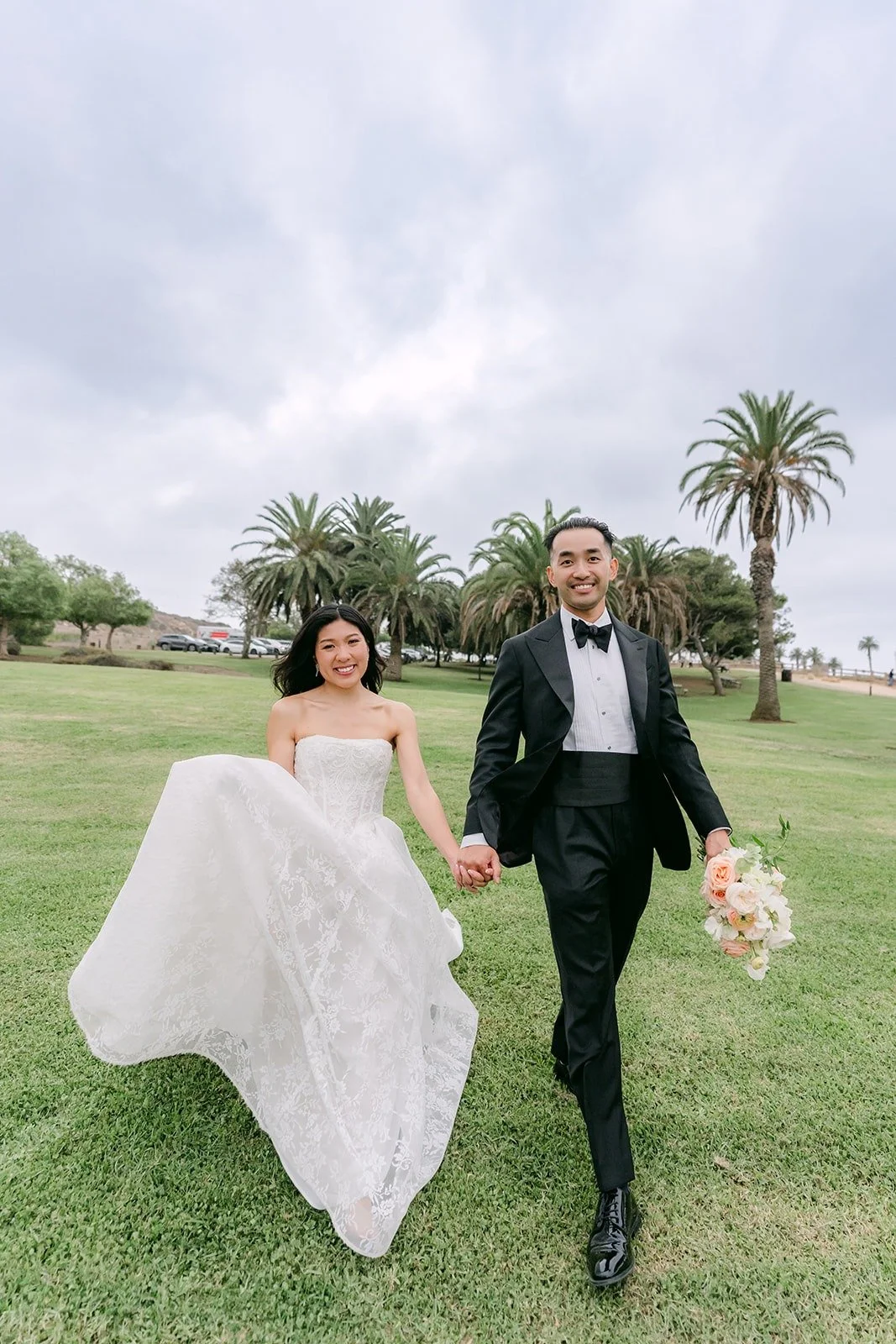 Kim and Vincent running across the lawn by the palms