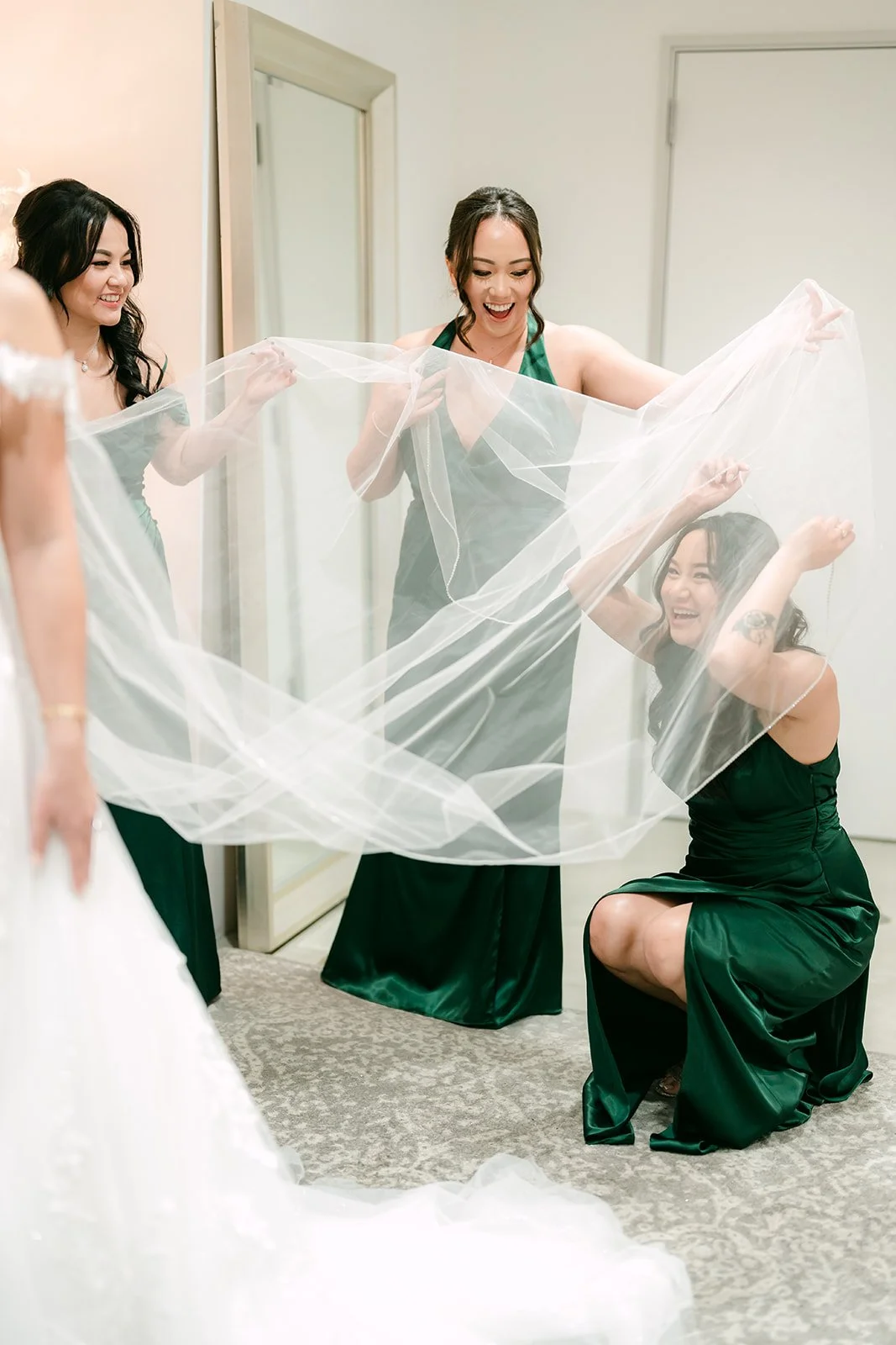 Bridesmaids lifting the bride's long cathedral veil