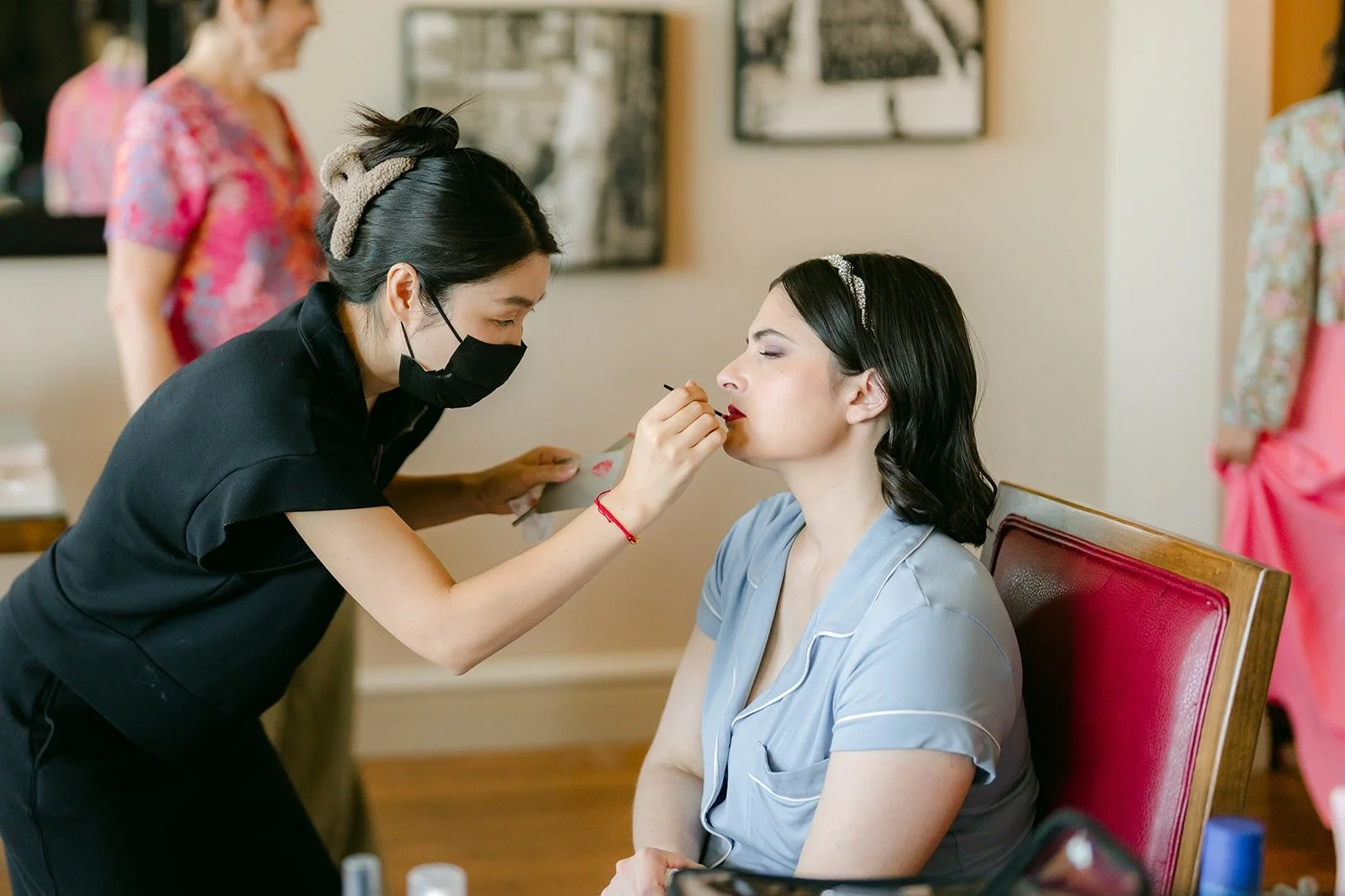 Jessie having her makeup done with her bridesmaids nearby