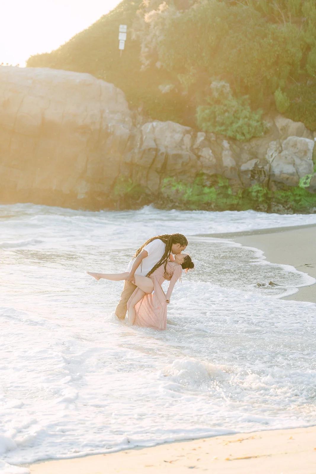 Amy splashing in the waves in her pink gown.