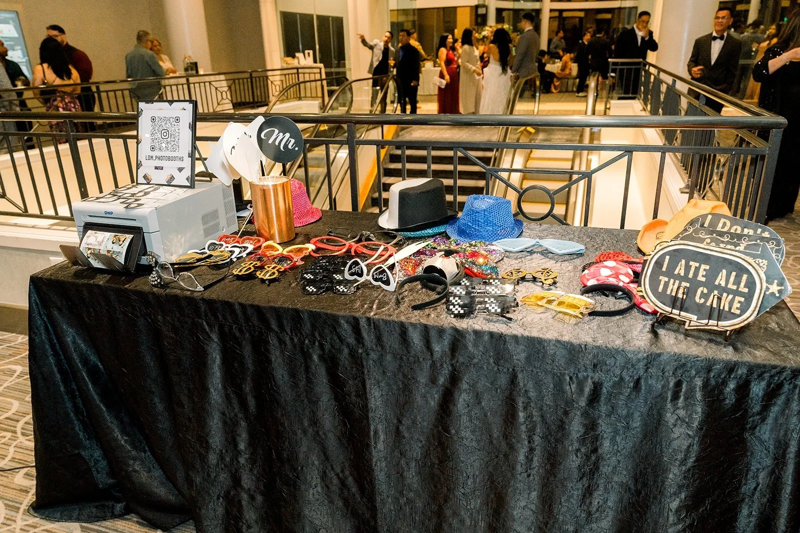 A photo booth table with props and a printer