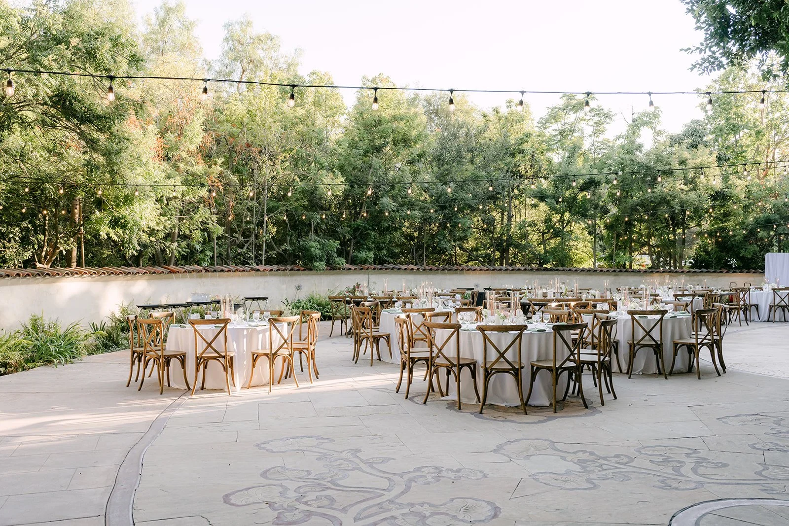 The reception patio at Eden Gardens set with wooden cross back chairs.