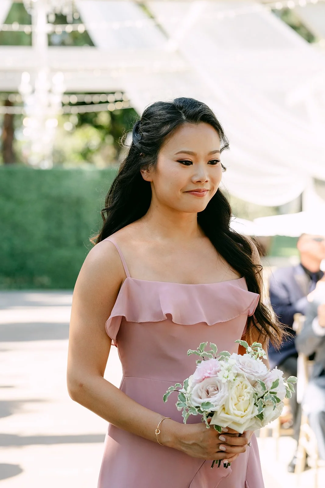 A bridesmaid holding her bouquet during the processional.