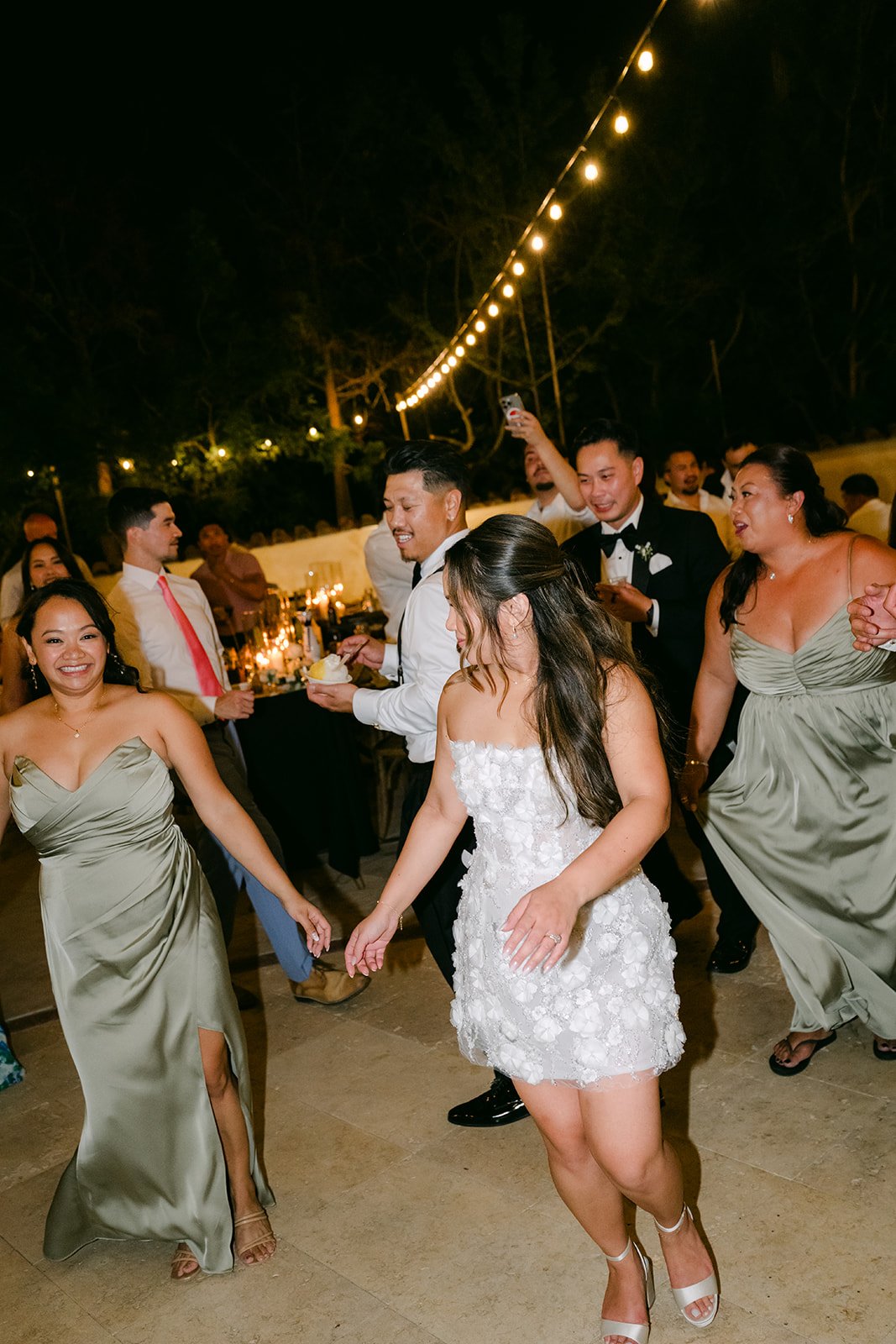Bridesmaids and guests dancing on the patio at Eden Gardens.