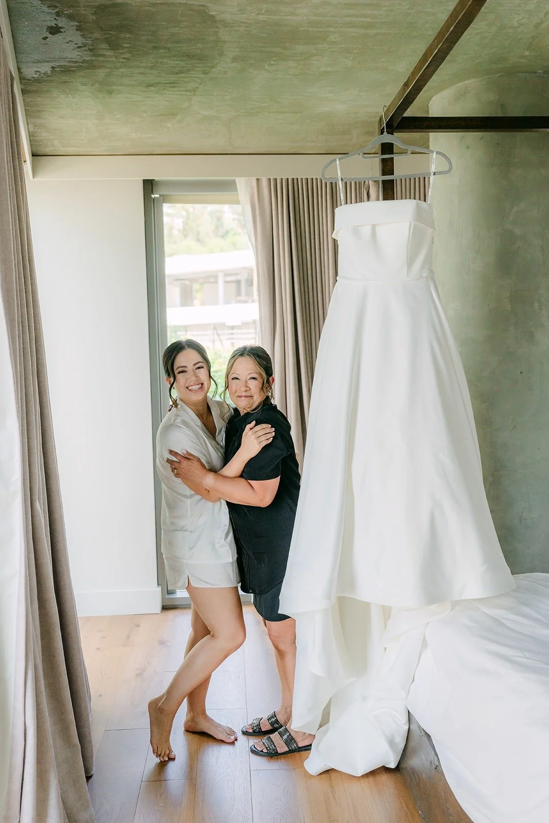 Brianna's bridesmaids laughing beside the gown