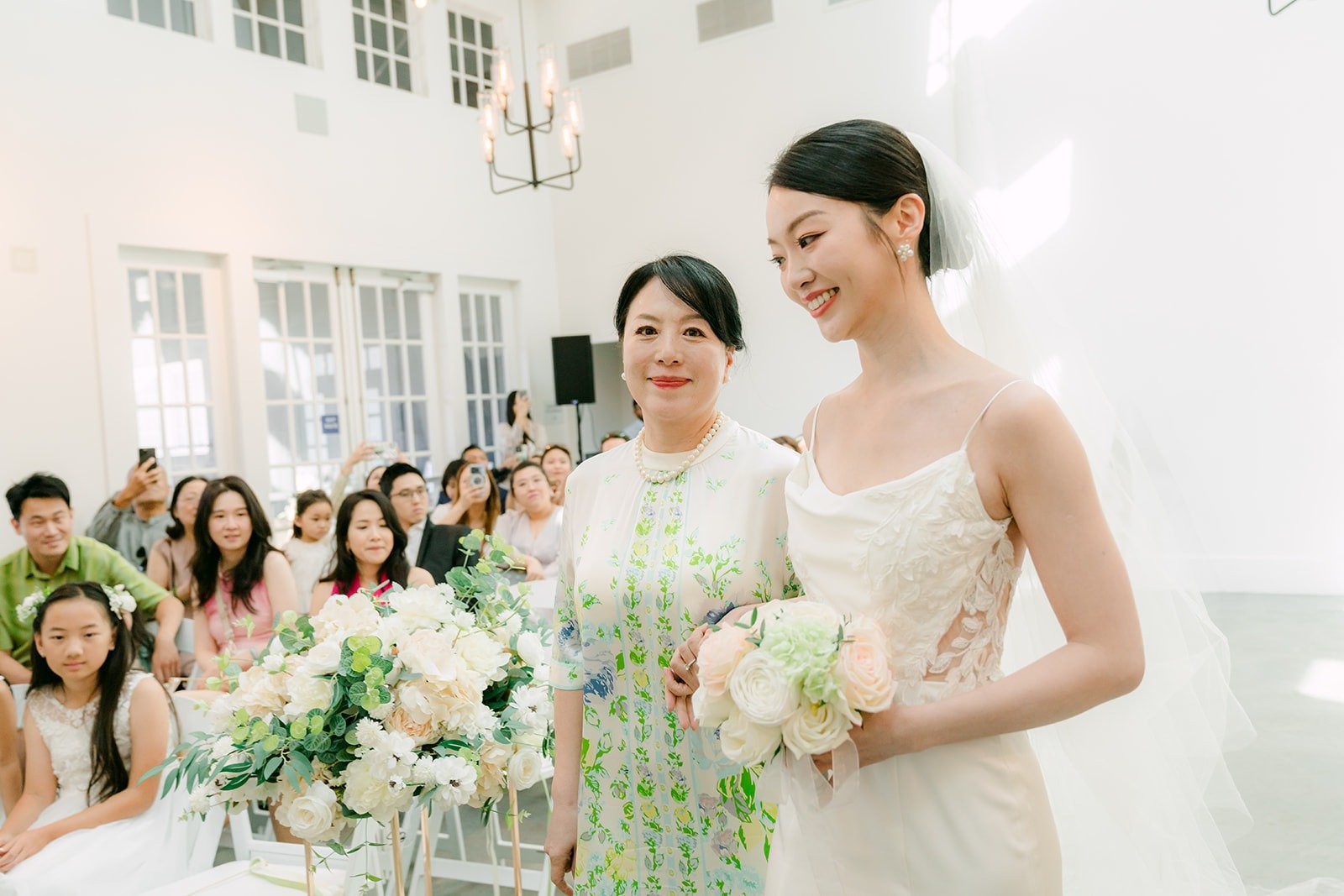 Tin smiling with a bridesmaid in the chapel