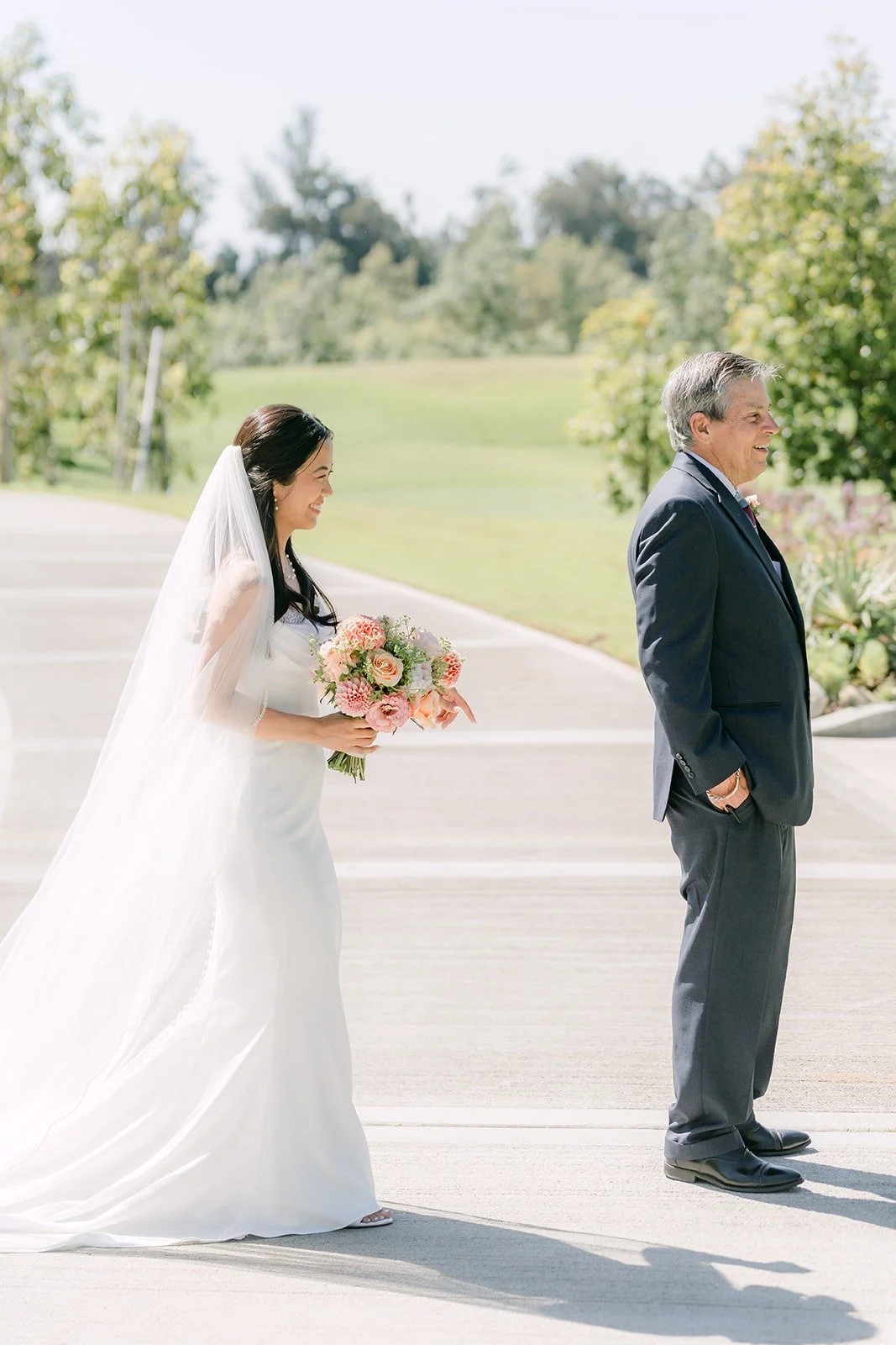 Stephanie walking up for a second first look with a family member in a gray suit