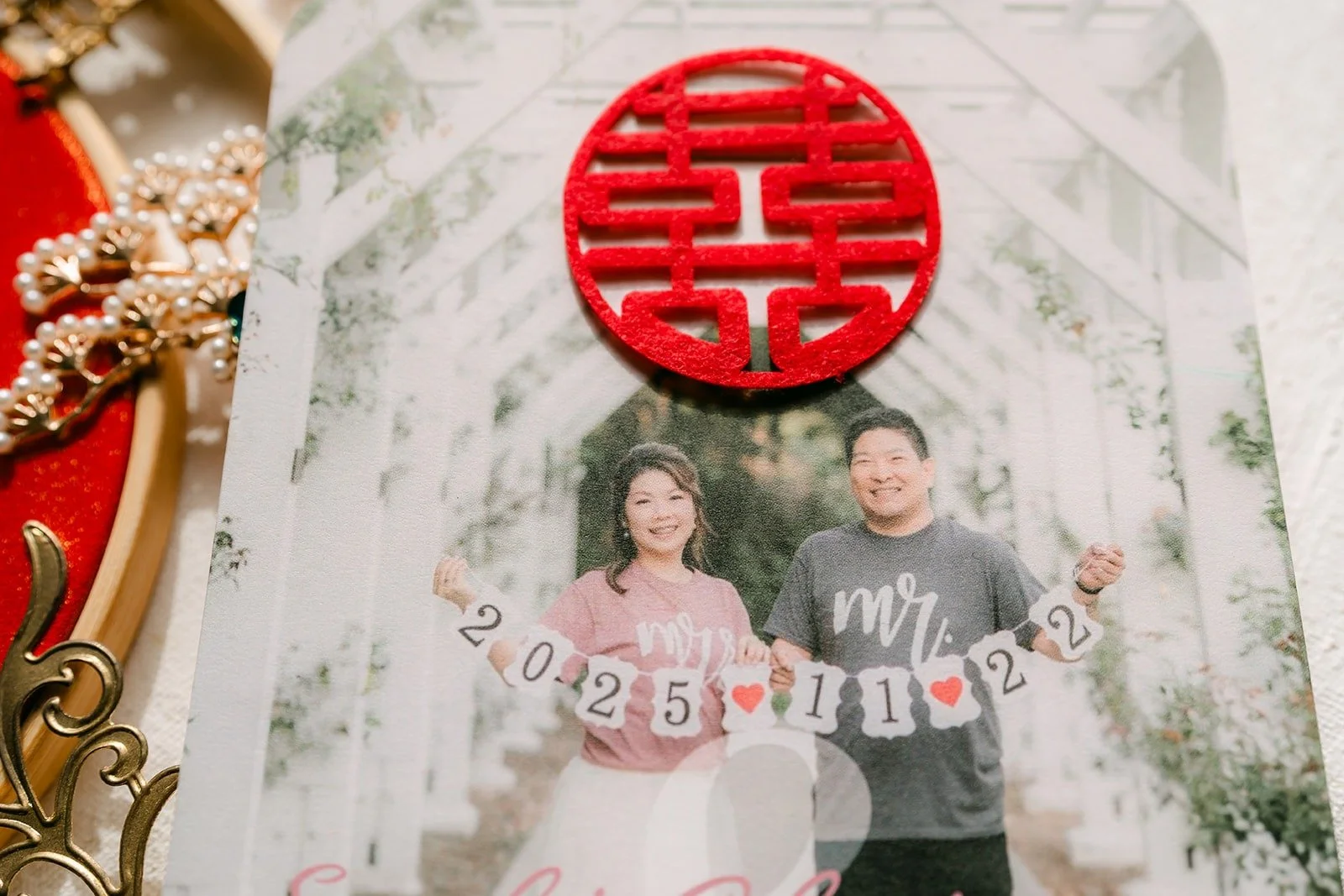 An engagement photo of Sochi and Jay behind a red double happiness ornament