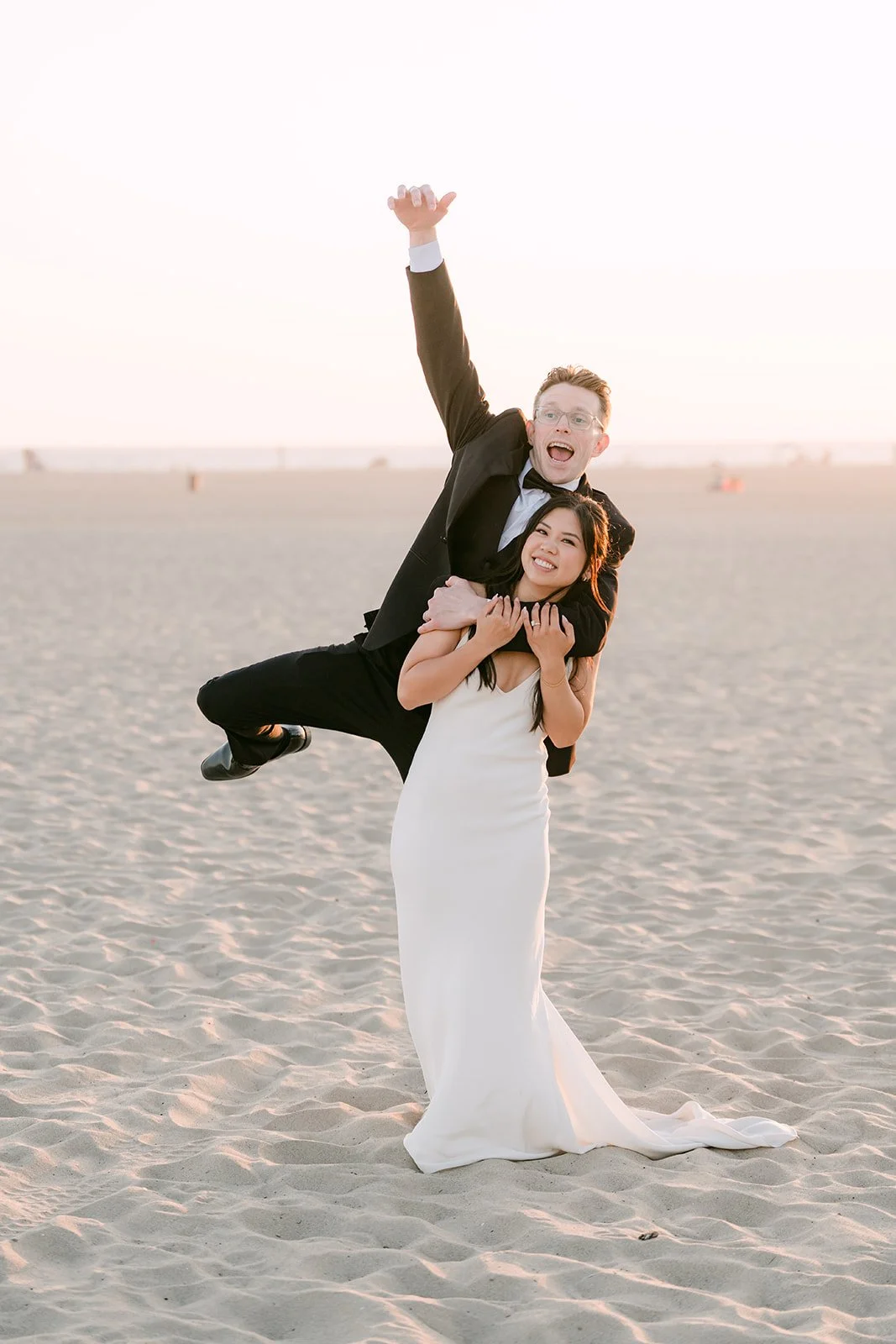 Matthew leaping over Justine on the beach