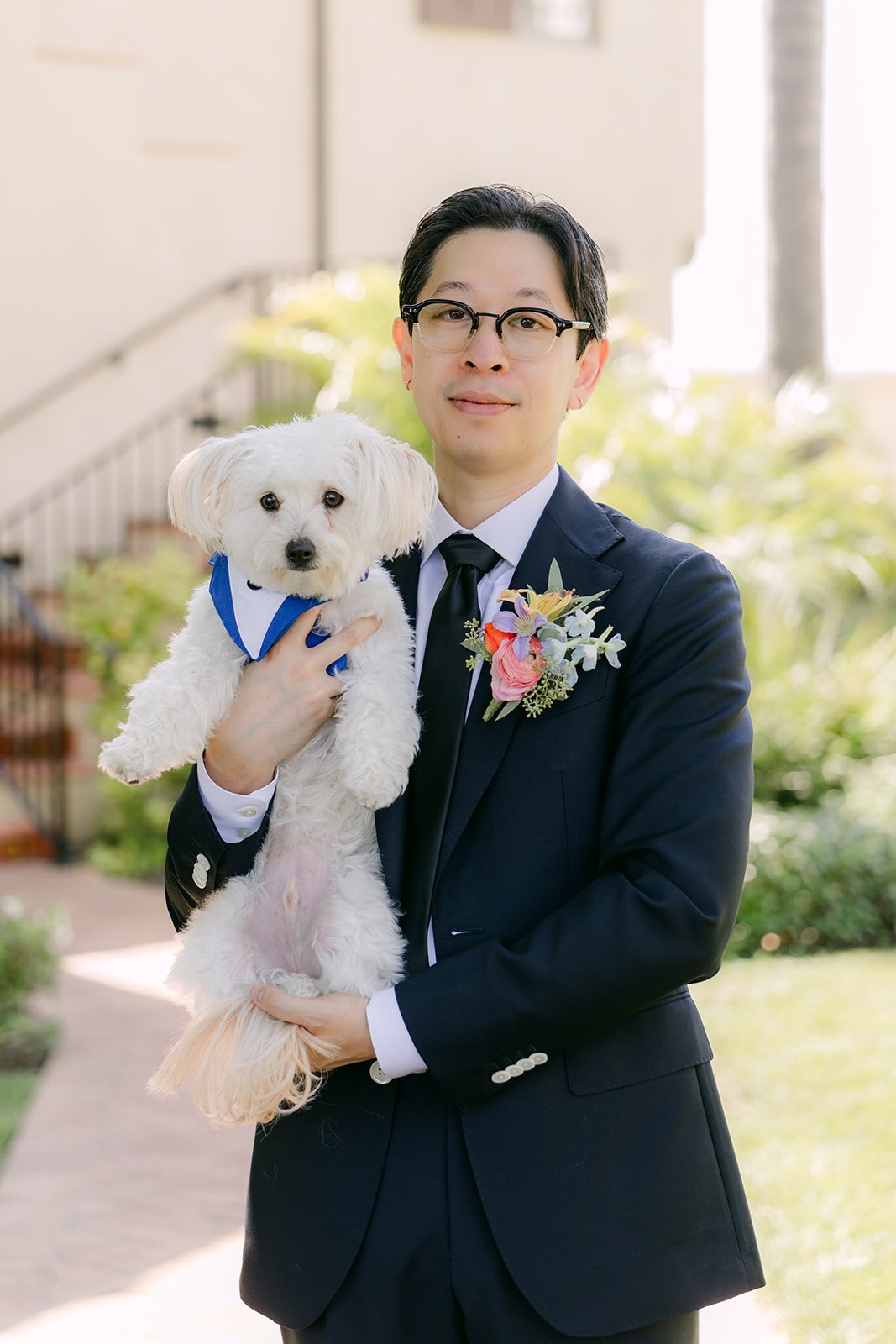 Leroy holding the pup in his boutonniere and navy suit