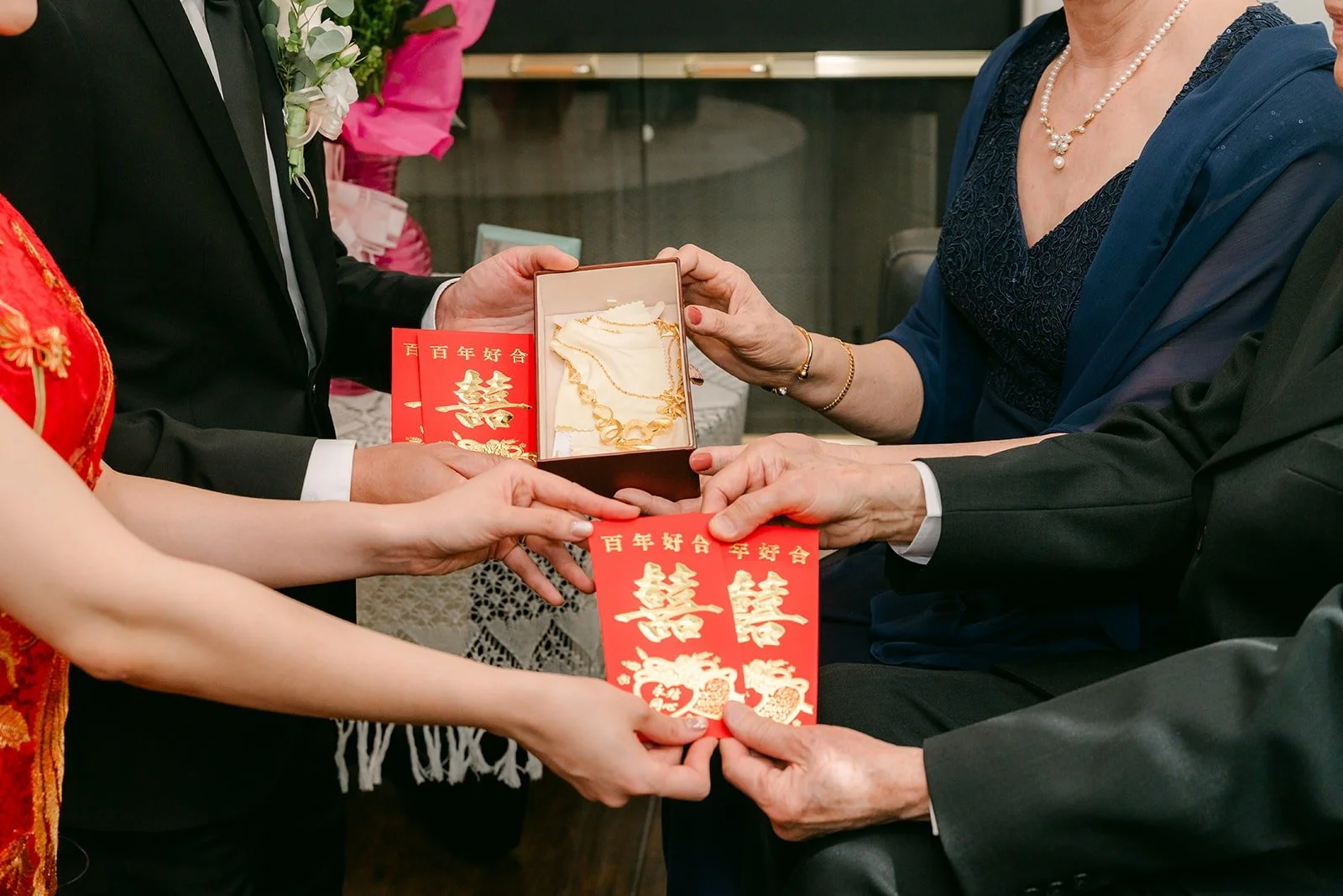 Close up of red envelopes with double happiness passing between hands