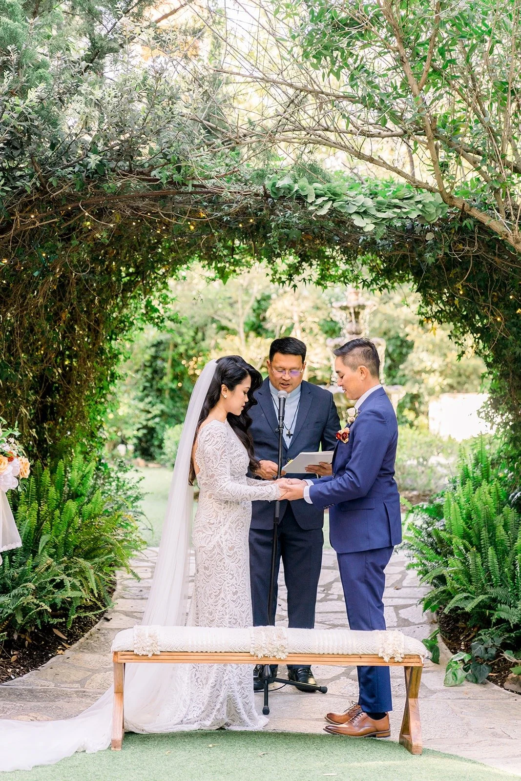 Hannah and Vincent at the arbor beside a wooden bench