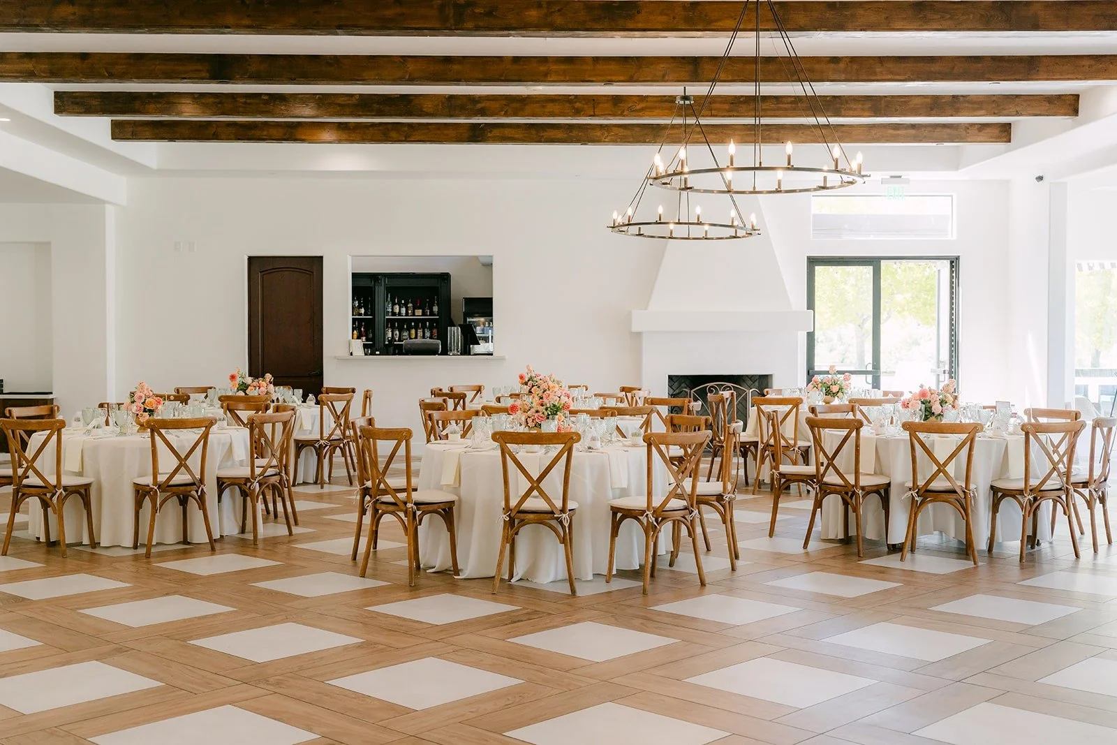 The reception room at Sterling Hills with round tables, wood chairs and a checkered floor
