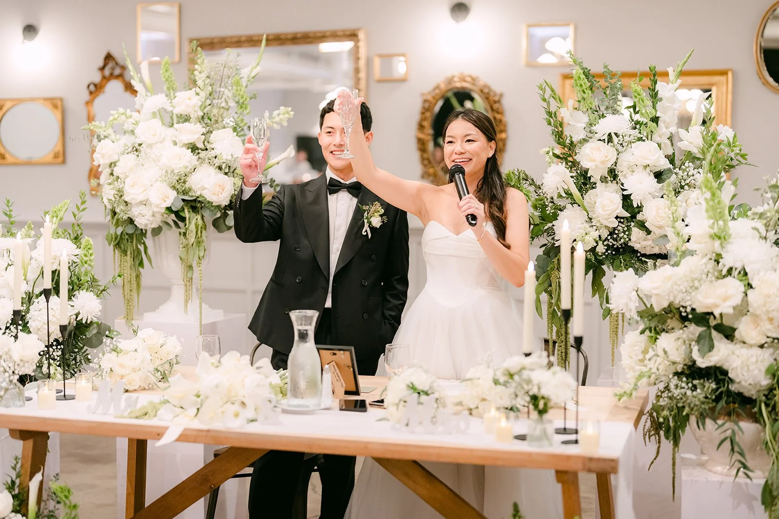 Jadee and Richard laughing at the sweetheart table during speeches