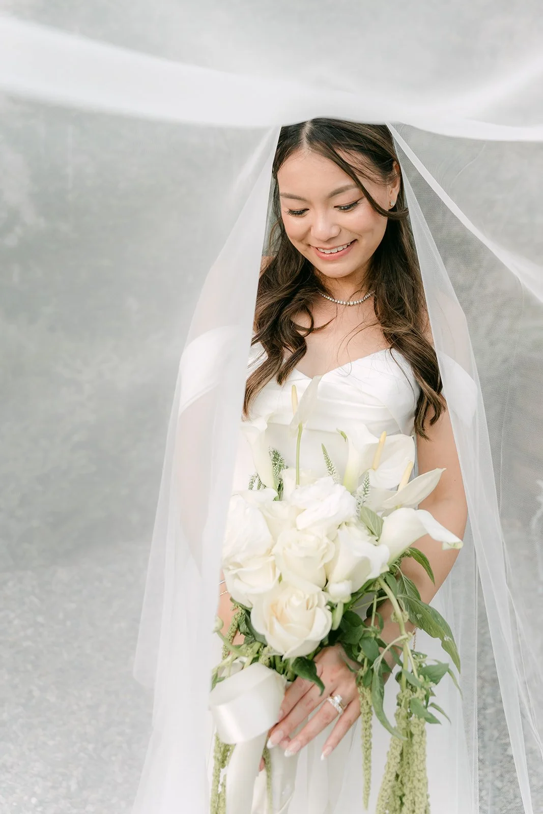Close portrait of Jadee under her veil with a white bouquet