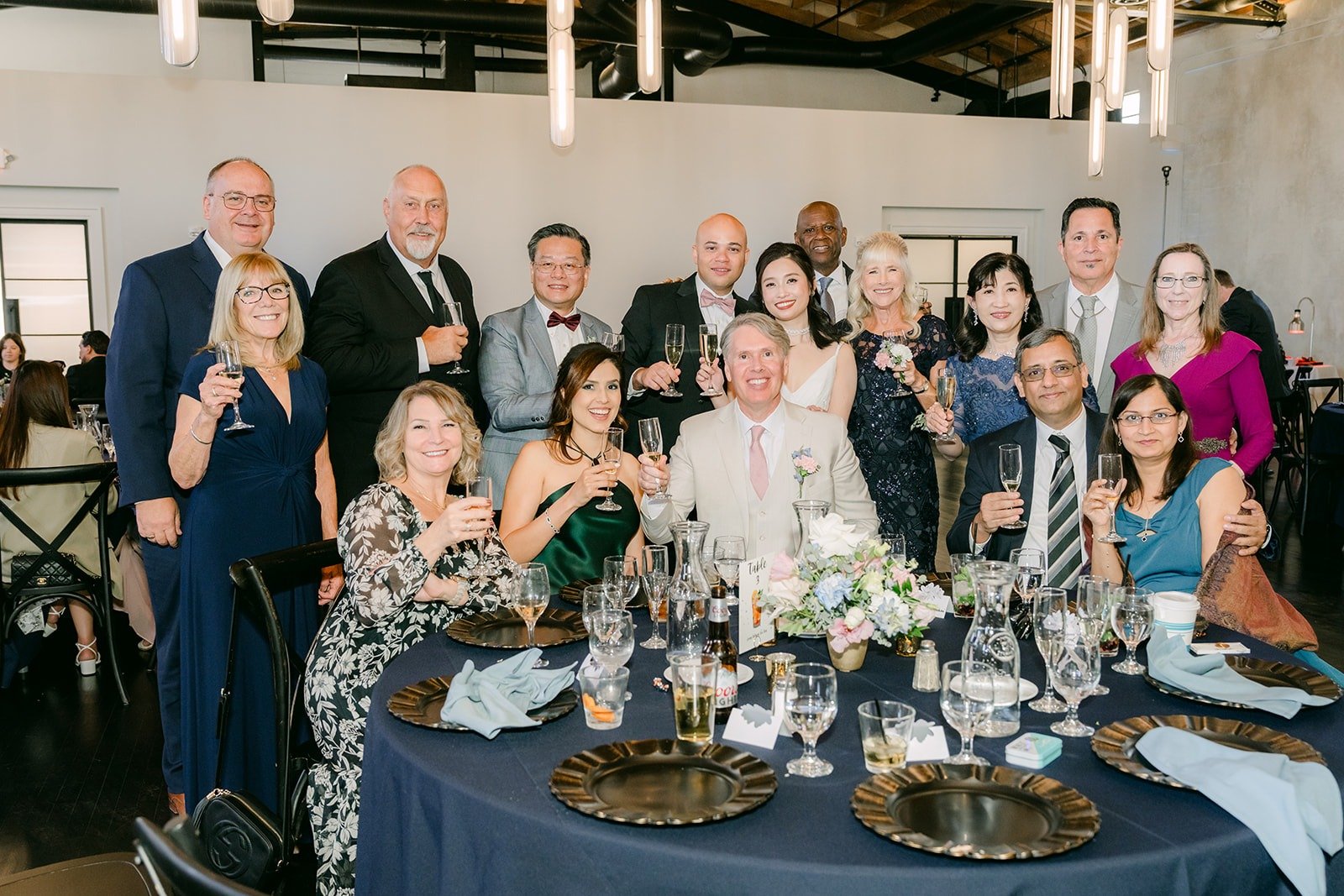 A table of guests raises their glasses during table toasts