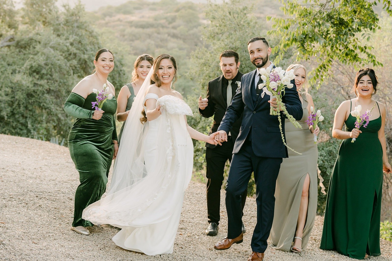 Mariana and Danny walking hand in hand with their wedding party
