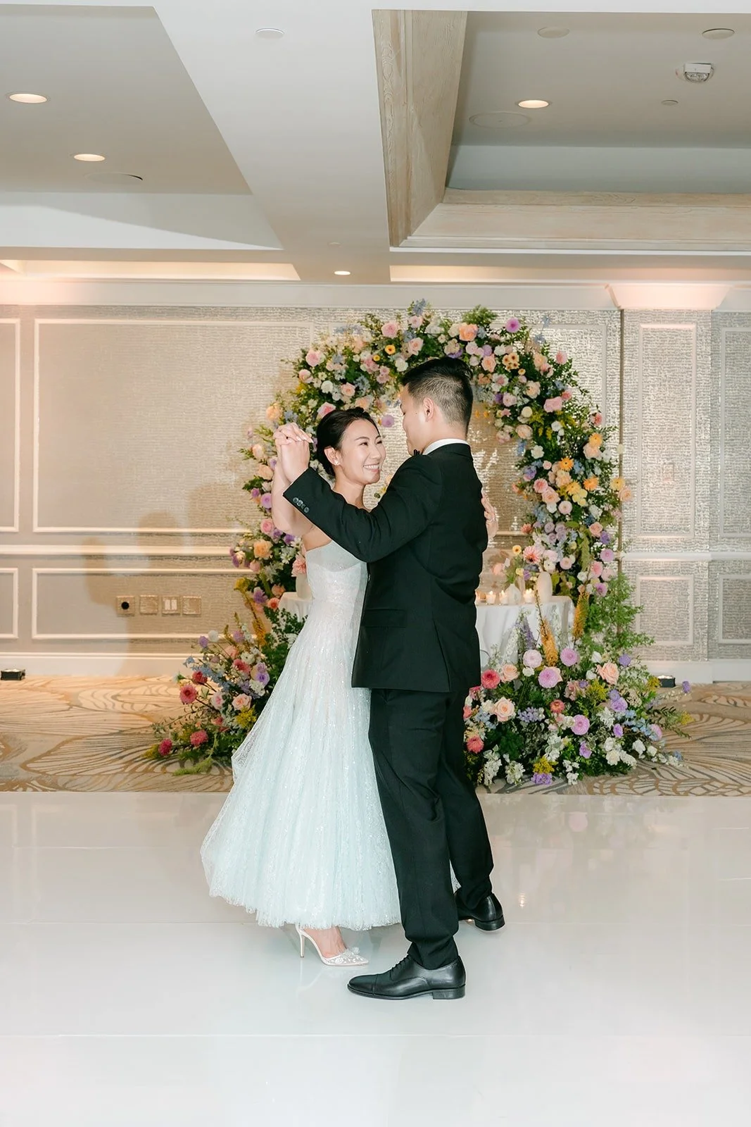 Kylie and Mario sharing their first dance on the white dance floor