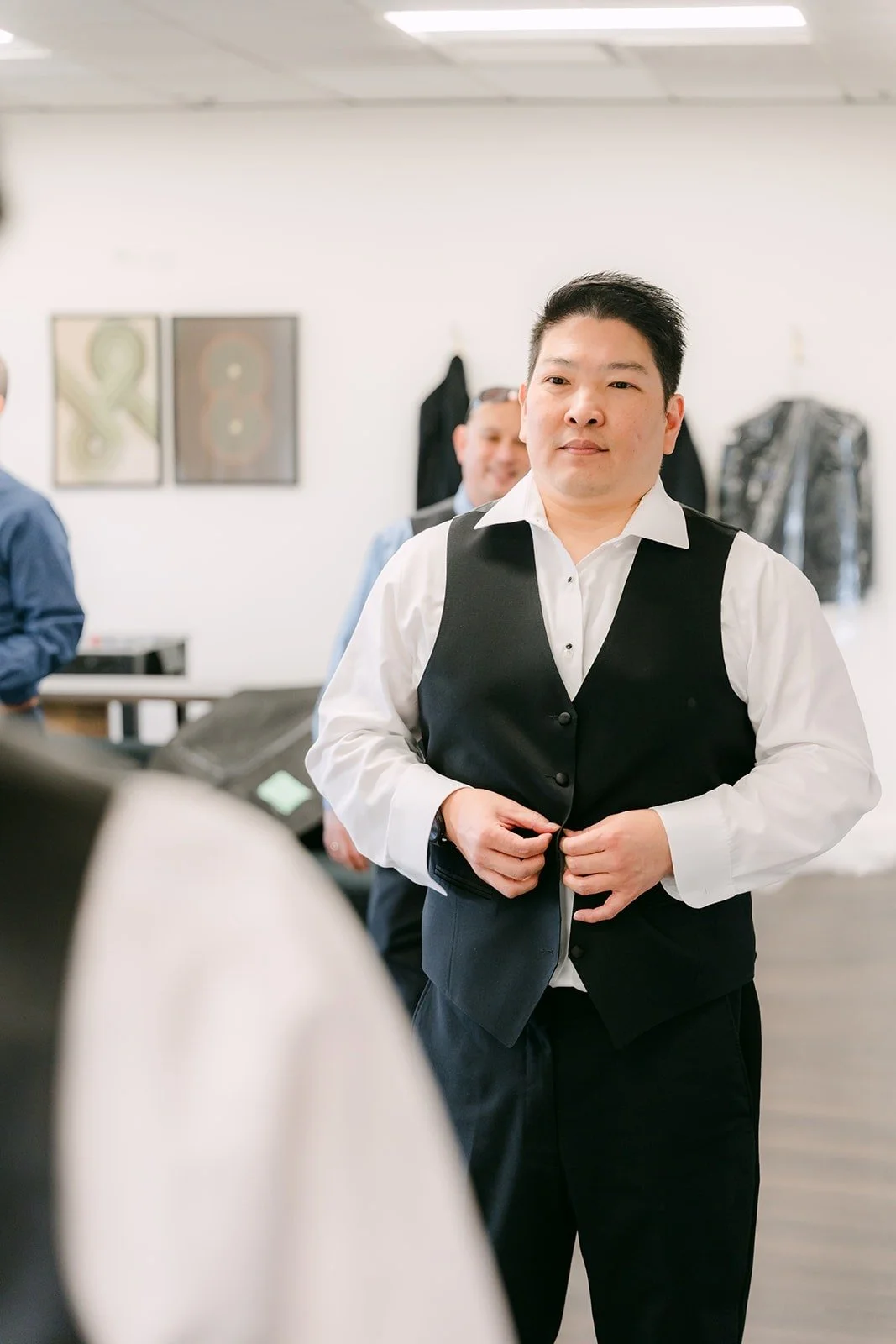 Jay in his white shirt and vest getting ready