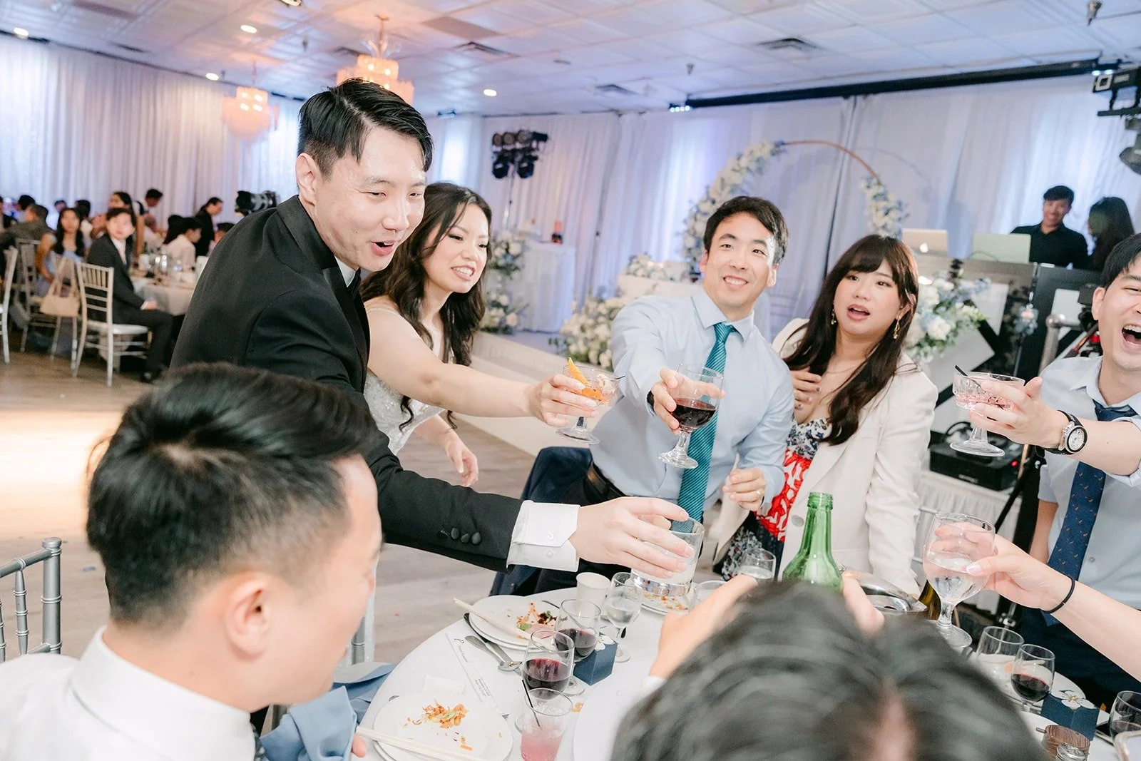 Emily and James toasting with guests during table greetings