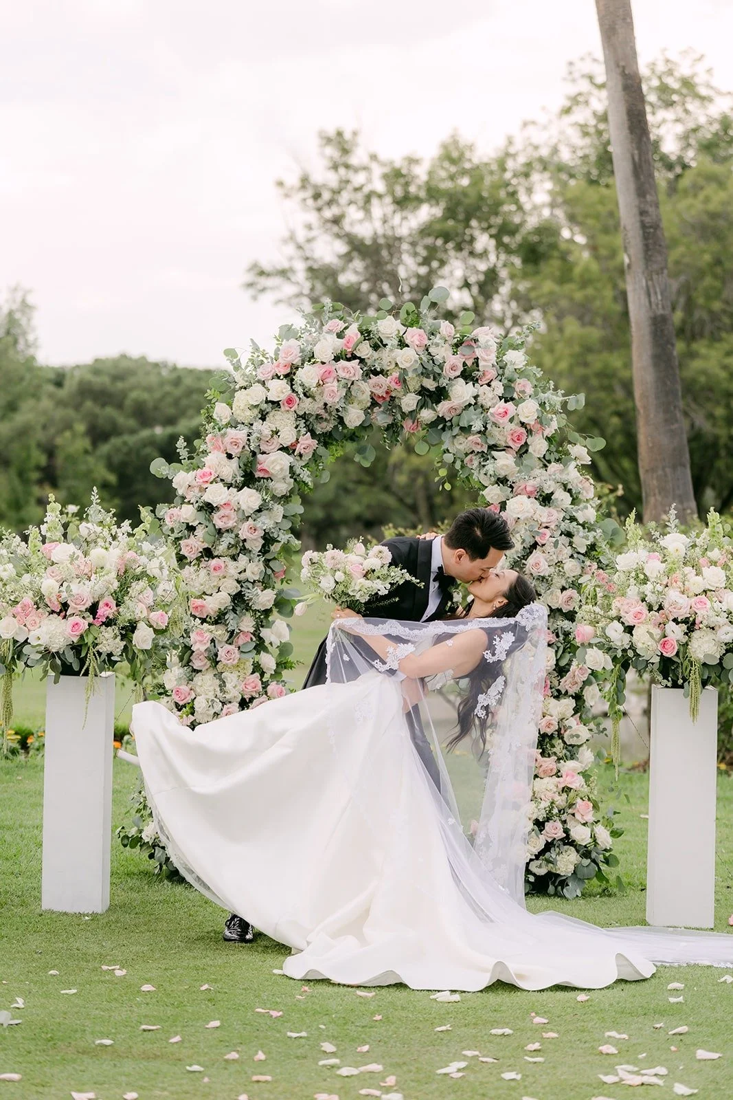 Kristine's train spread on the grass in front of the floral arch