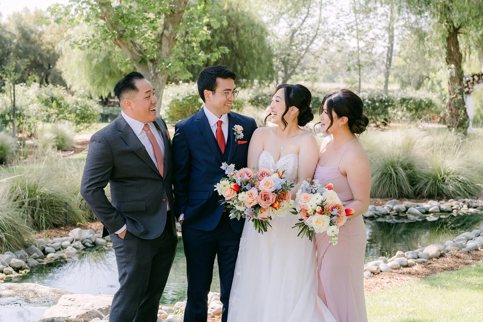 Bride and groom with their maid of honor and best man in the garden
