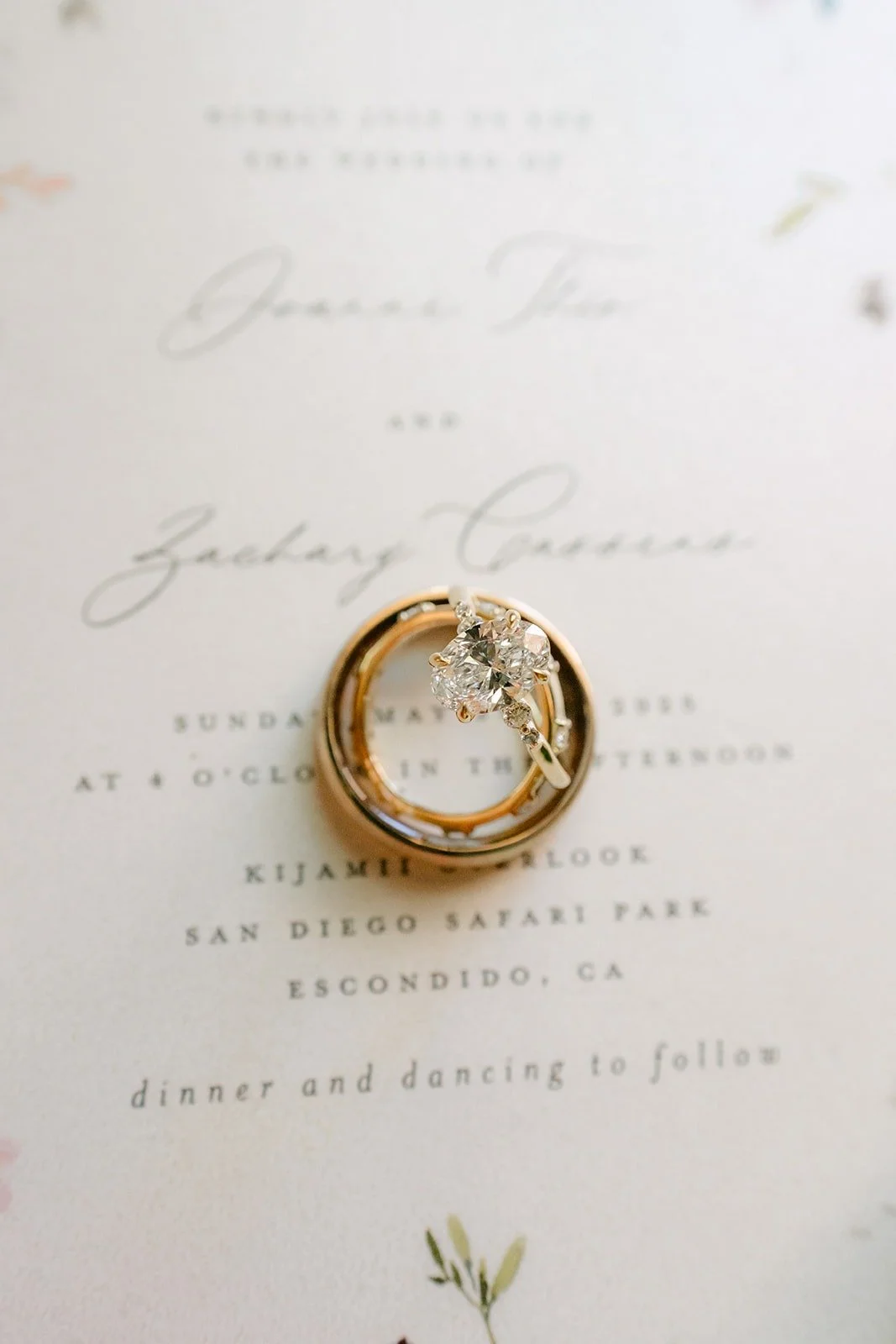 The wedding rings resting on Joanne and Zachary's invitation suite