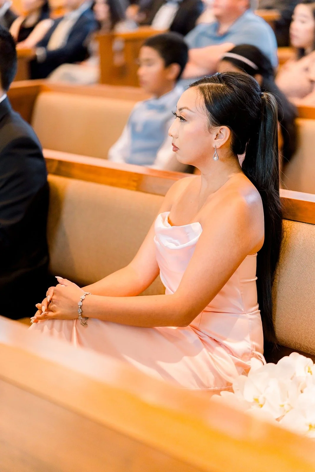 A bridesmaid watches from the front pew