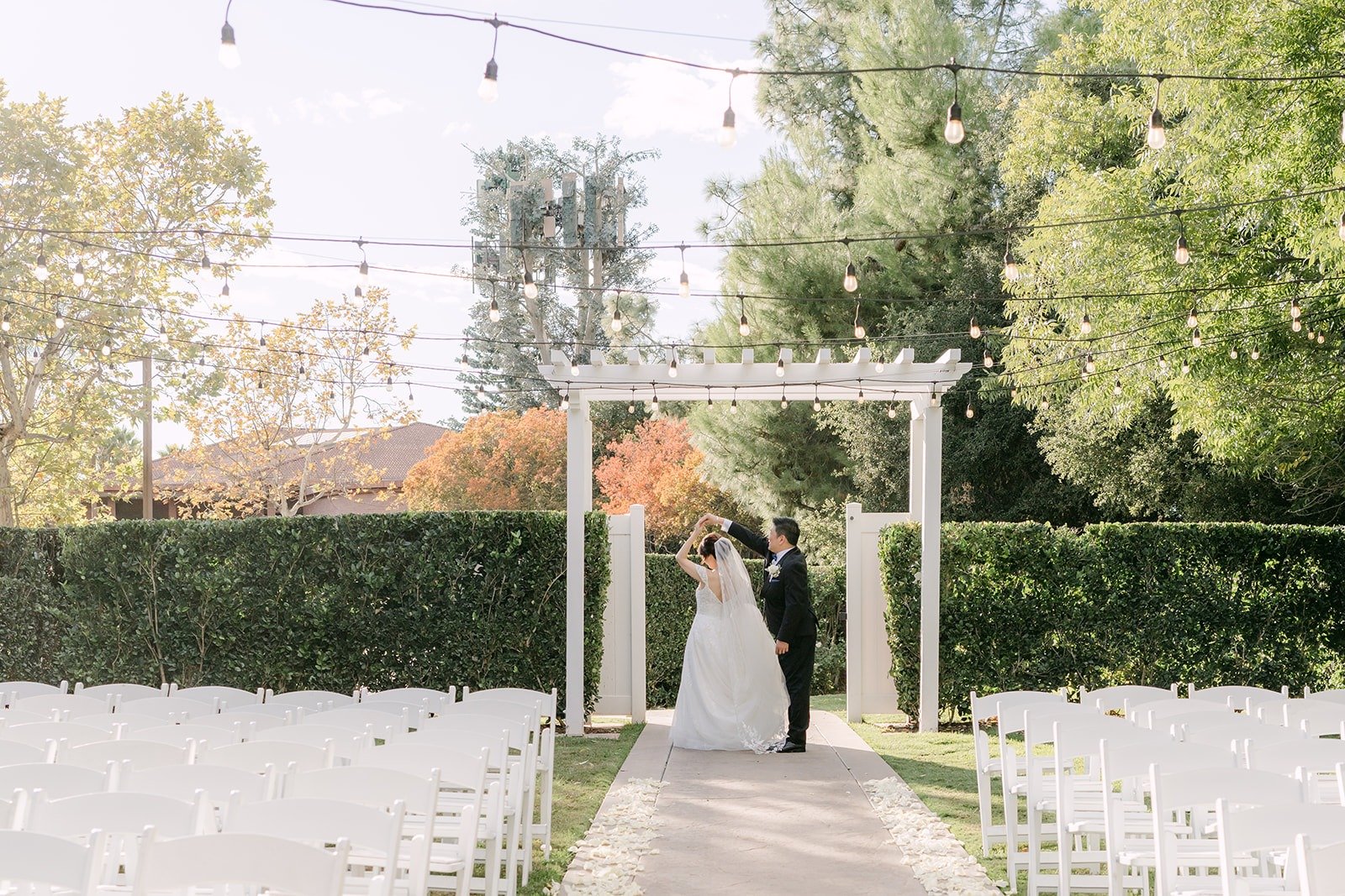 A wide view of Sochi and Jay at the end of the aisle among the white chairs