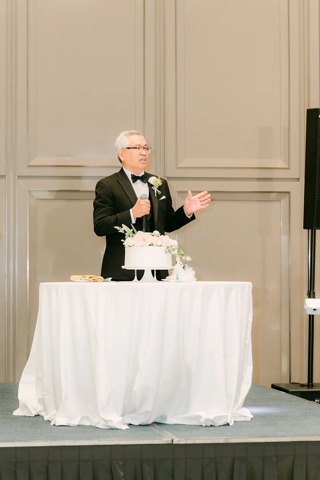 A guest giving a speech from the stage in the ballroom