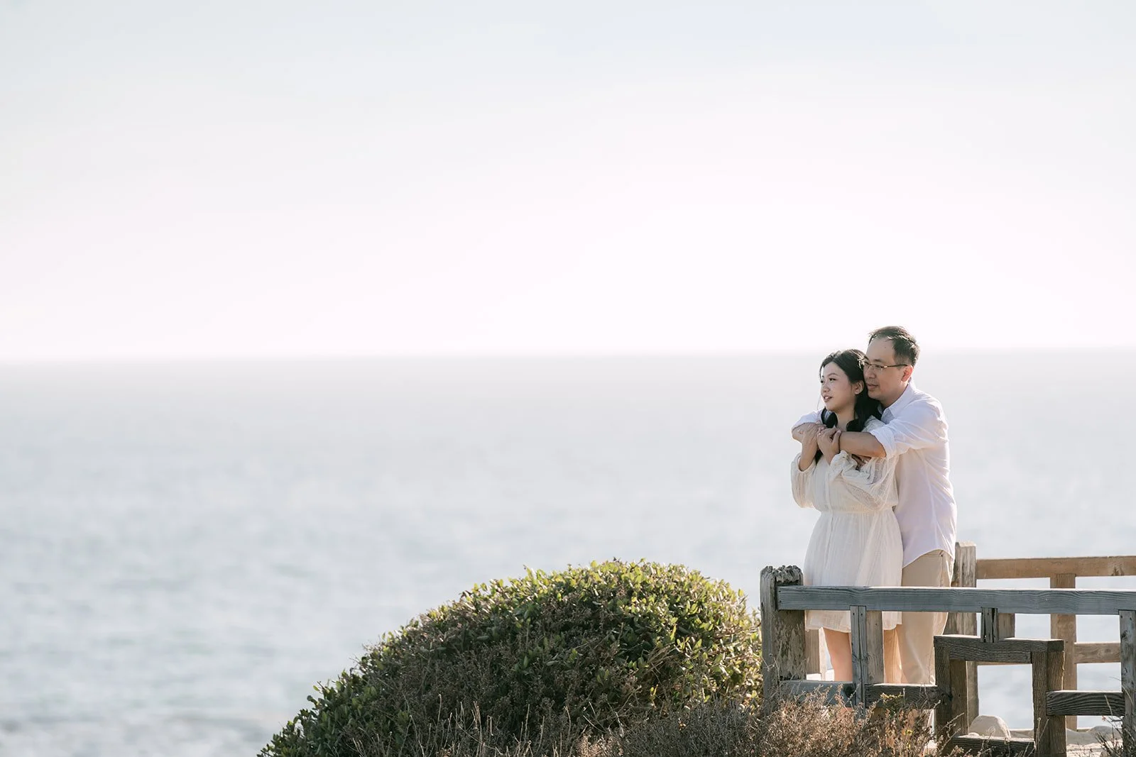 Constance and Lawrence at the bluff railing above the ocean.